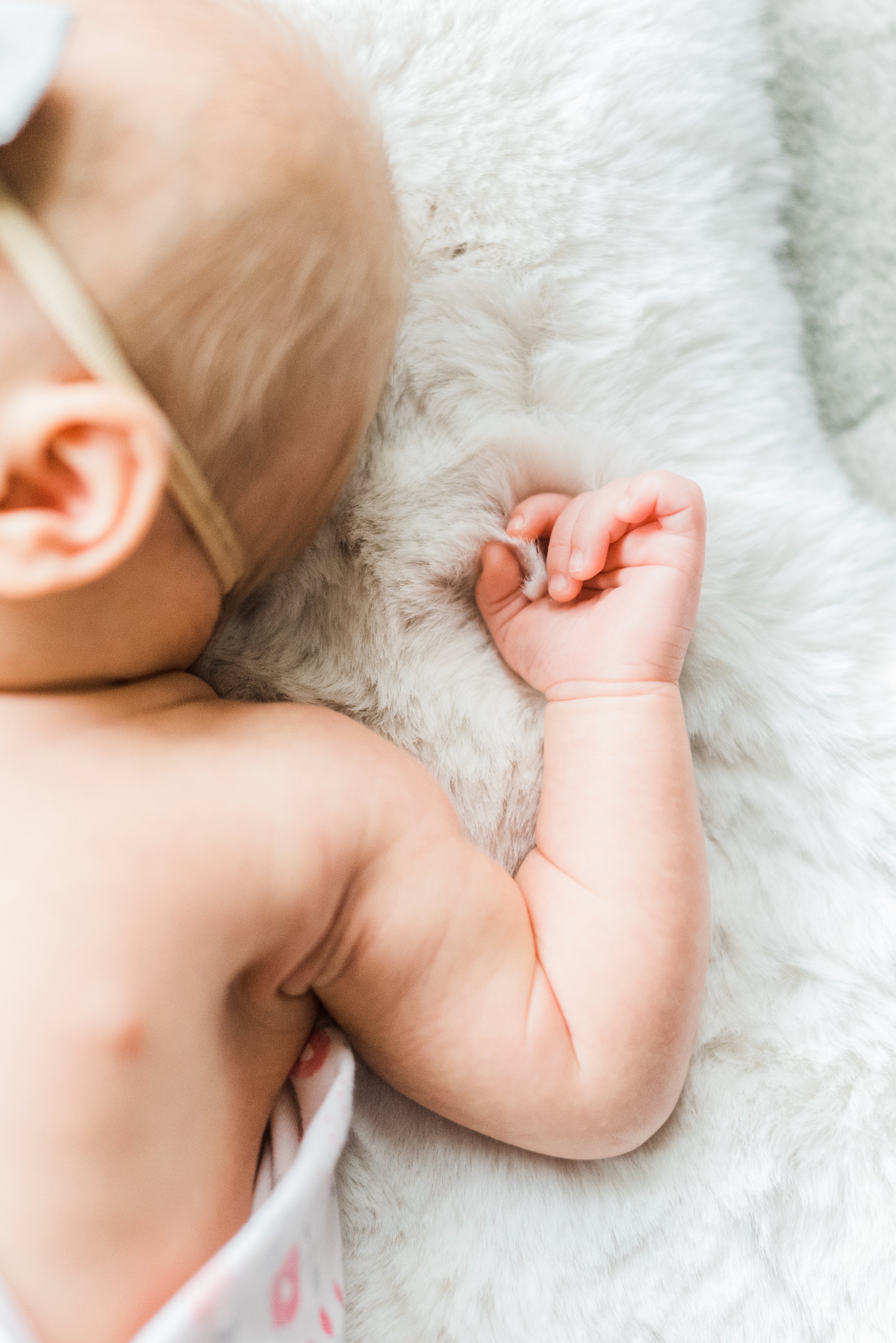  A close-up photo of a newborn girl gripping the fluffy blanket with her tiny hand. Newborn photo session DIY newborn photos #naturallight #newbornphotographytips #diyphotography #momphotographer #photographytips 