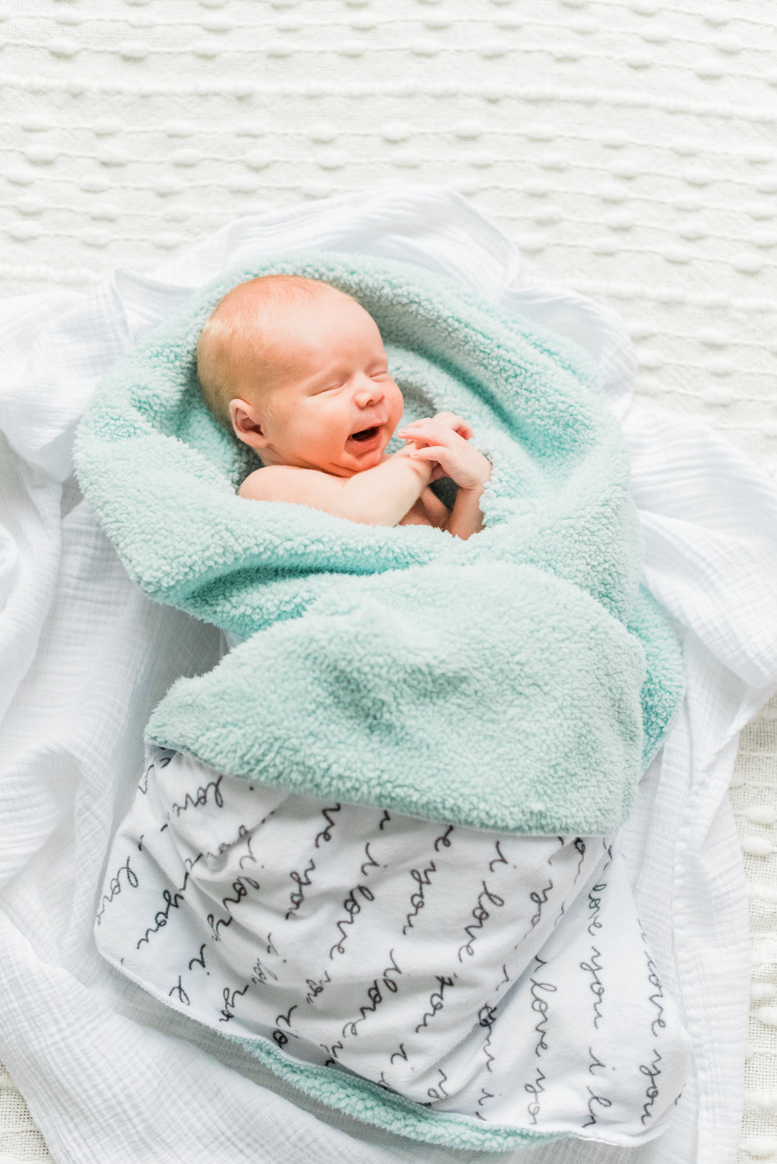  A newborn baby is captured mid-yawn while cuddled in his blanket. Newborn photo session DIY newborn photos Senoia, GA #naturallight #newbornphotographytips #diyphotography #momphotographer #photographytips&nbsp; 
