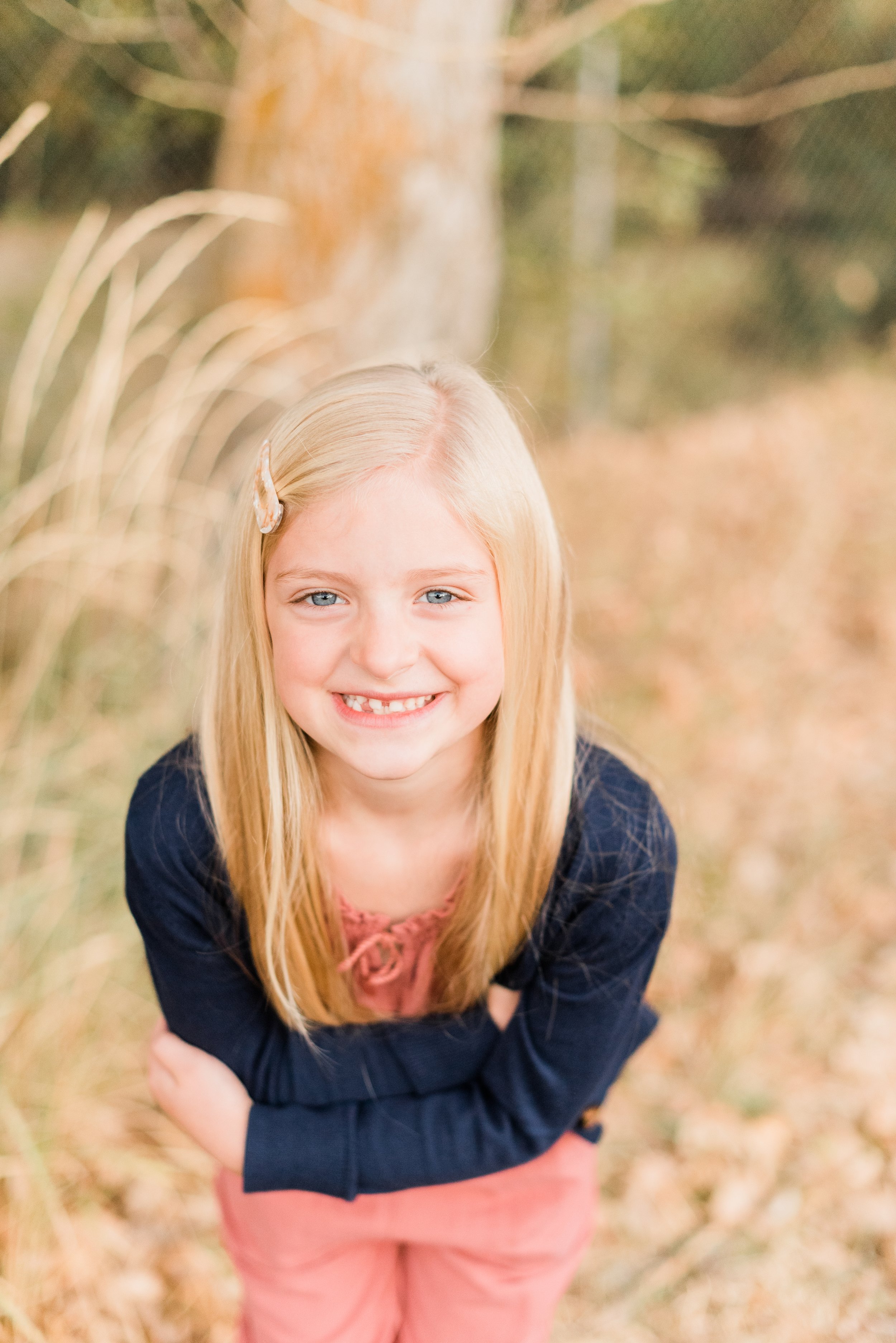  A sweet blonde little girl leans forward with her arms folded, smiling for her portrait photo taken by Jacquie Erickson, a Georgia-based family photographer. Posing guide Alpharetta GA momtog course &nbsp; #diyphotography #firstdayofschoolphotos #ca