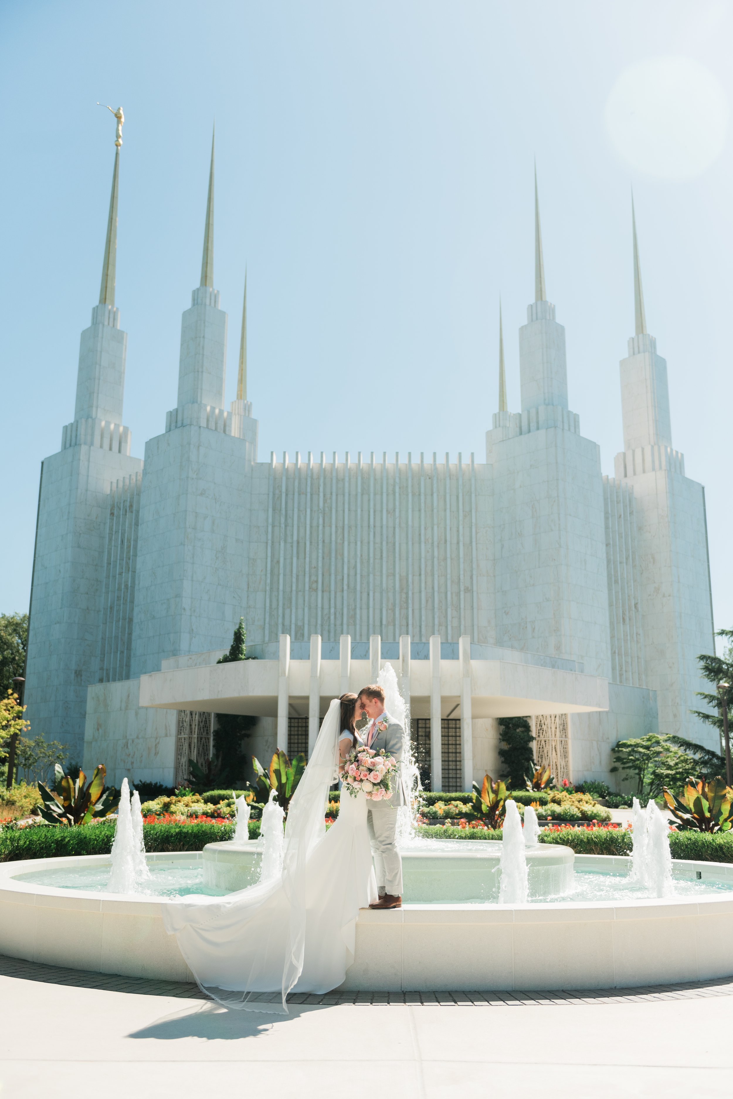  A bride and groom share a kiss on the fountain after their sealing in the Atlanta, Georgia LDS temple. #marylandweddingphotographer #atlantaweddingphotographer #brideandgroom #justmarriedphotos #bridalportraits #weddingdayphotos #Atlantatemple #LDSt