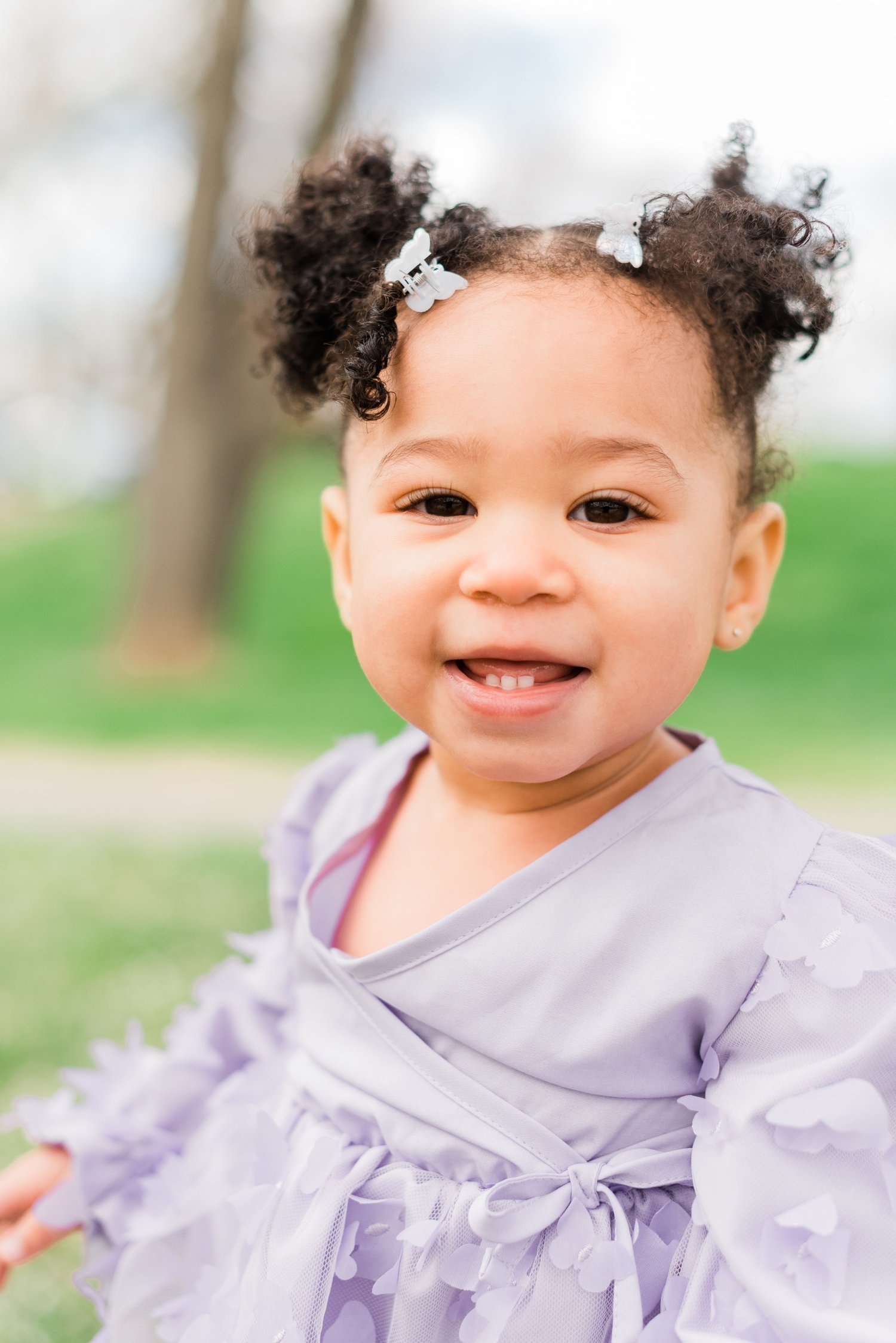  A little girl with curly pigtails shows her little teeth and a cheesy grin captured by Fayetteville photographer, Jacquie Erickson. Children's portraits capture their childhood #childportraits #childrenphotographer #notyourschoolpicture #georgiaphot