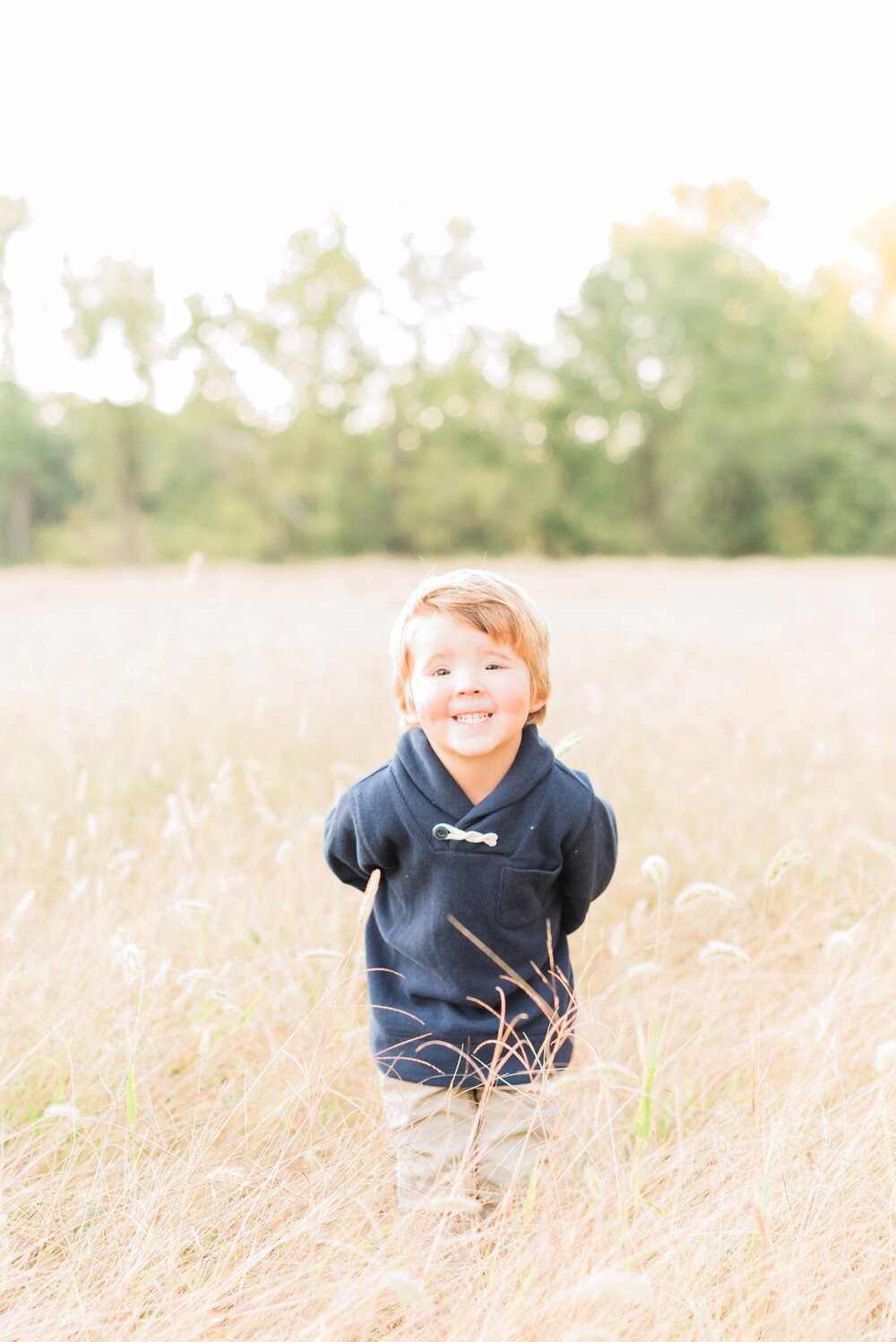  A little boy shows his cheesy grin in a grassy field during a photo shoot by Jackie Erickson, a Roswell photographer. Children's portraits capture their childhood #childportraits #childrenphotographer #notyourschoolpicture #georgiaphotographer 