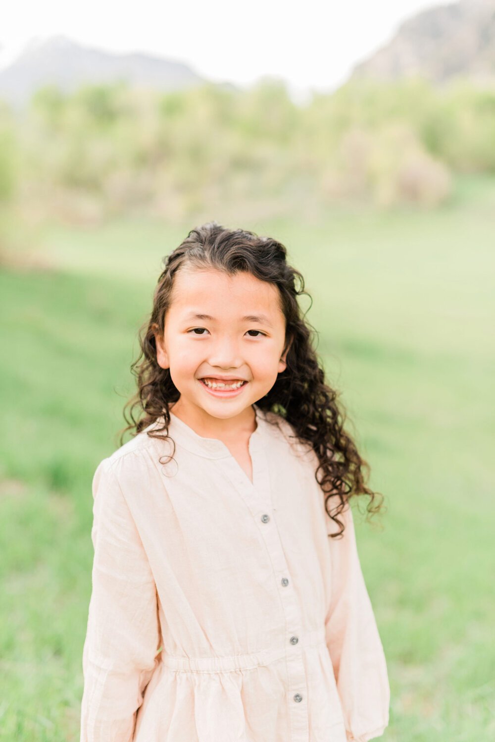  A girl with curly brown hair smiles during a photoshoot by Atlanta-based photographer, Jacquie Erickson.&nbsp; Personalized kid's portraits capture their childhood little girl portraits Fayetteville Peachtree City&nbsp; #childportraits #childrenphot