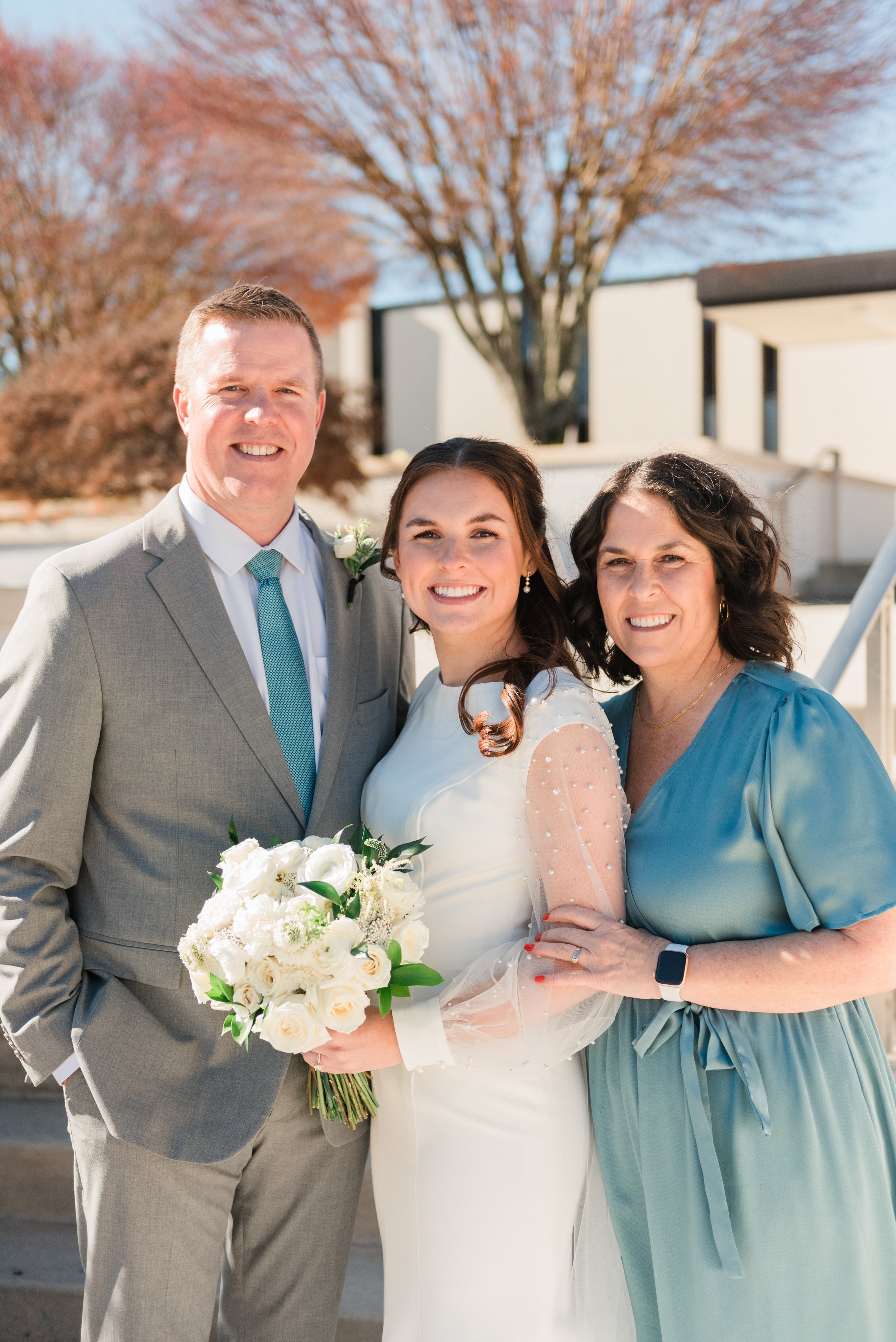  A bride is embraced by her mom and dad outside the Atlanta, Georgia LDS temple. Bride and parents&nbsp; Peachtree City White wedding flowers #Fayetteville #weddingphotographer #ldsweddings #atlantatemple #weddingbouquet&nbsp; #jacquieerickson 