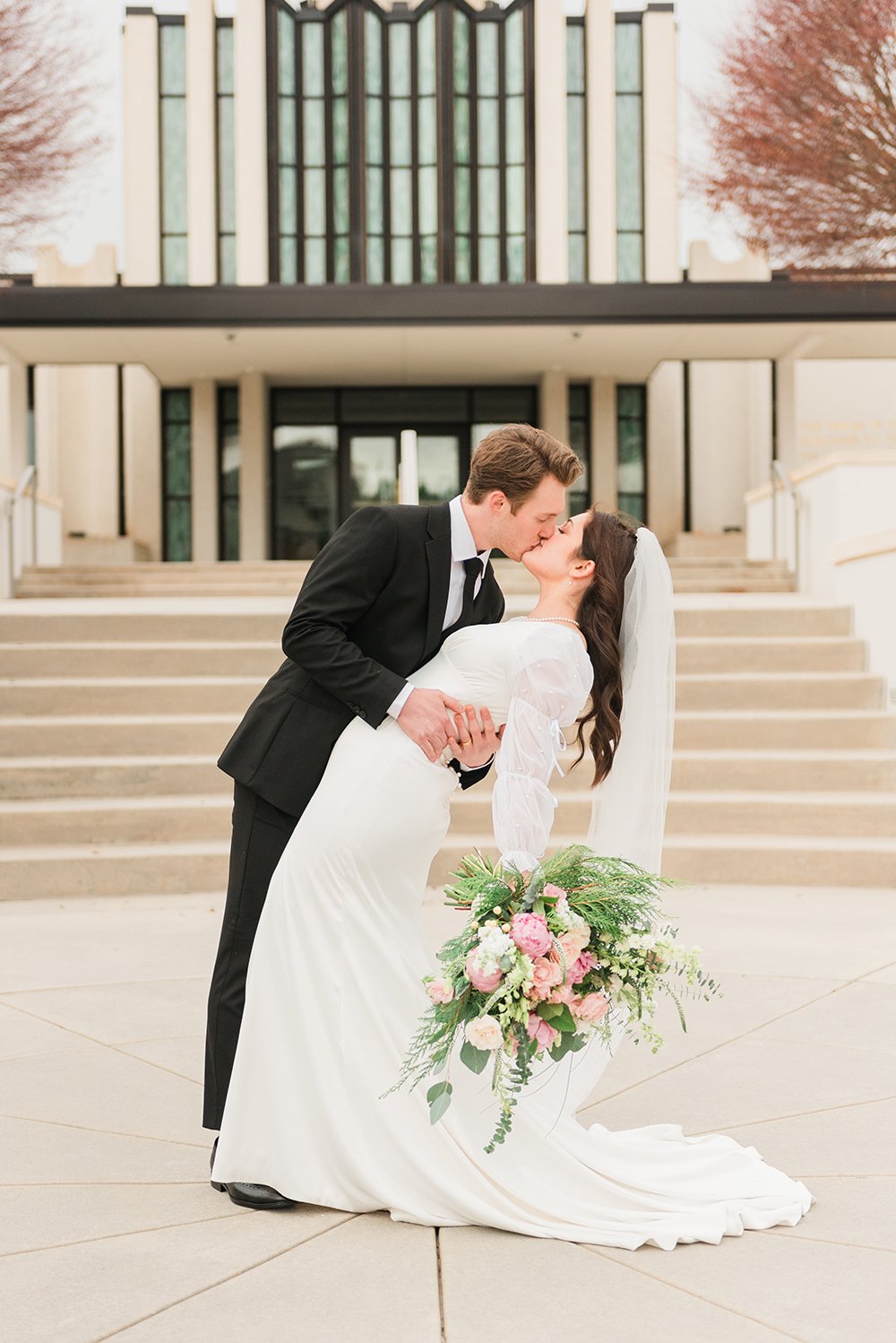  A husband dips and kisses his new bride in front of the Atlanta, Georgia LDS temple. Professional wedding photographer temple wedding pictures#peachtreecity #weddingphotographer #ldsweddings #atlantatemple #jacquieerickson #weddingkiss 