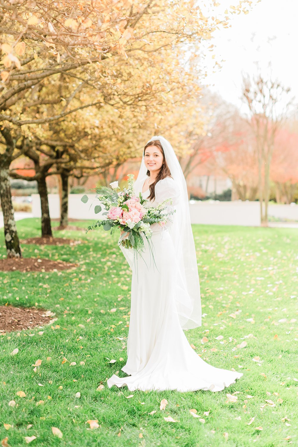  Jacquie Erickson, an Atlanta-based photographer, captures a bride standing on a grassy lawn holding her wedding bouquet. Bridal photos wedding photographer Sharpsburg Roswell #weddingphotographer #ldsweddings #atlantatemple #jacquieerickson #bridalp