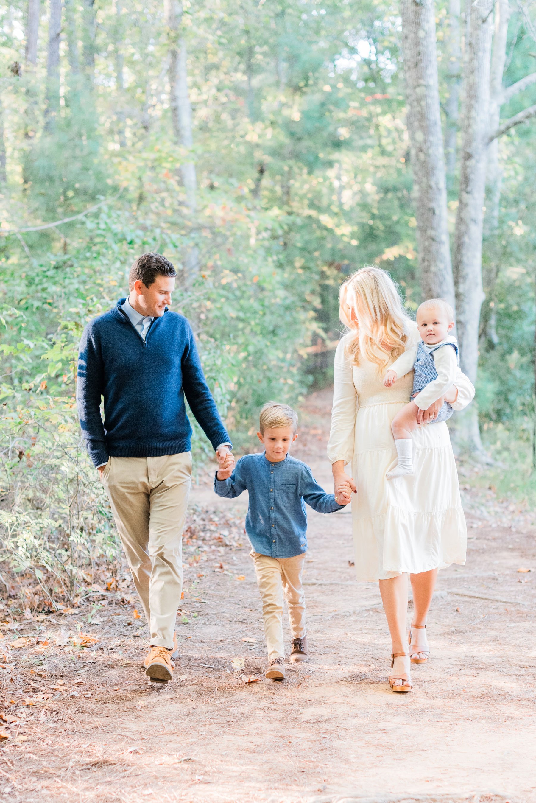  This family of four walks down a wooded path in Georgia during their photo session by Jacquie Erickson. Jacquie Erickson Atlanta Georgia Peachtree City Fayetteville Senoia photo color palette #photoshootoutfits #photocolorpalette #familypictures #at