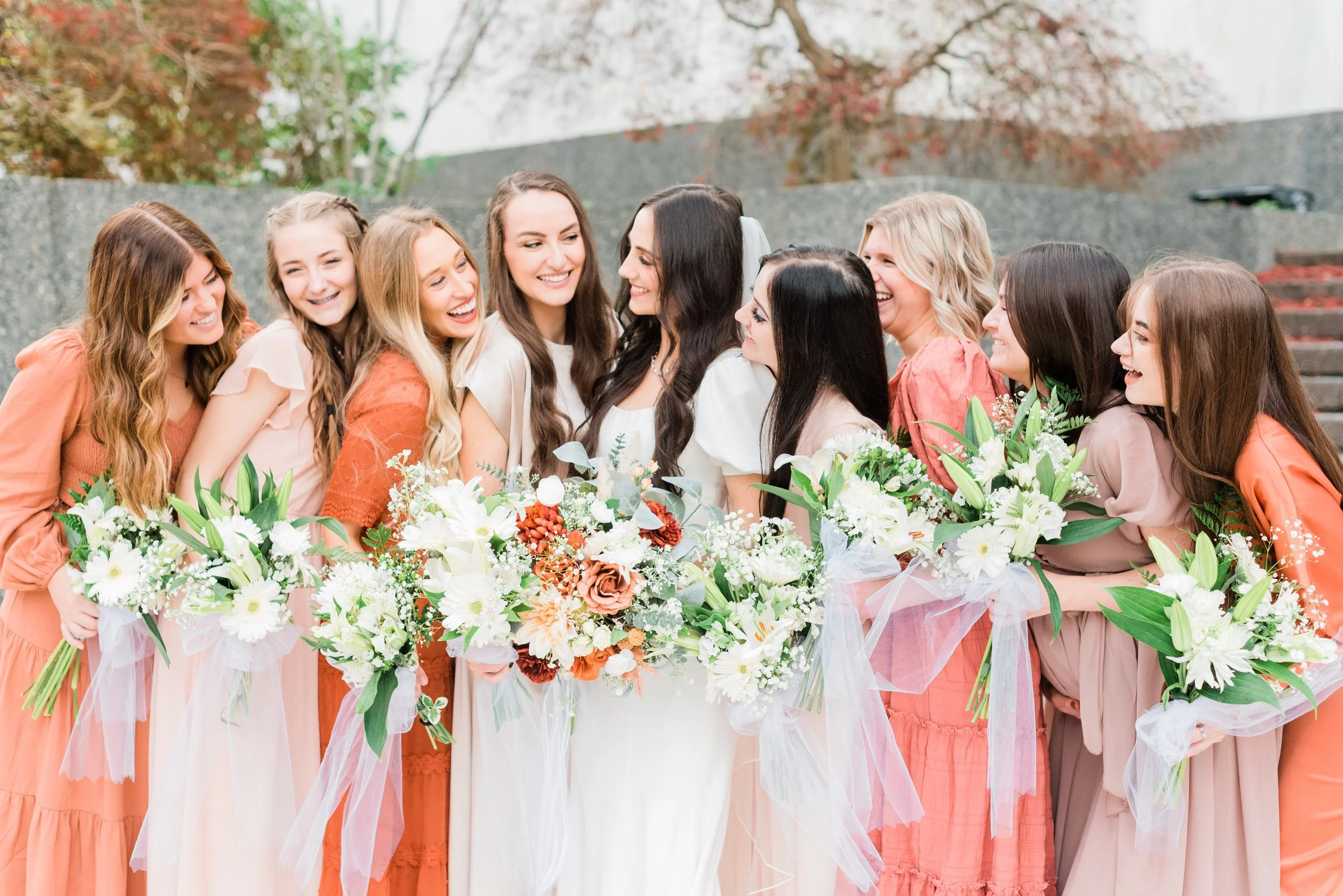 Bridesmaids wearing orange and beach snuggle together and laugh with the bride by Jacquie Erickson Photography. orange bridesmaid #JacquieEricksonPhotography #JacquieEricksonWeddings #DCLDSTemple #DCwedding #WinterWeddingDC #DCweddingphotographer