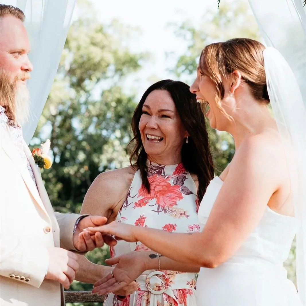 sunshine-coast-celebrant-laughing-with-bride-and-groom-during-wedding-ceremony