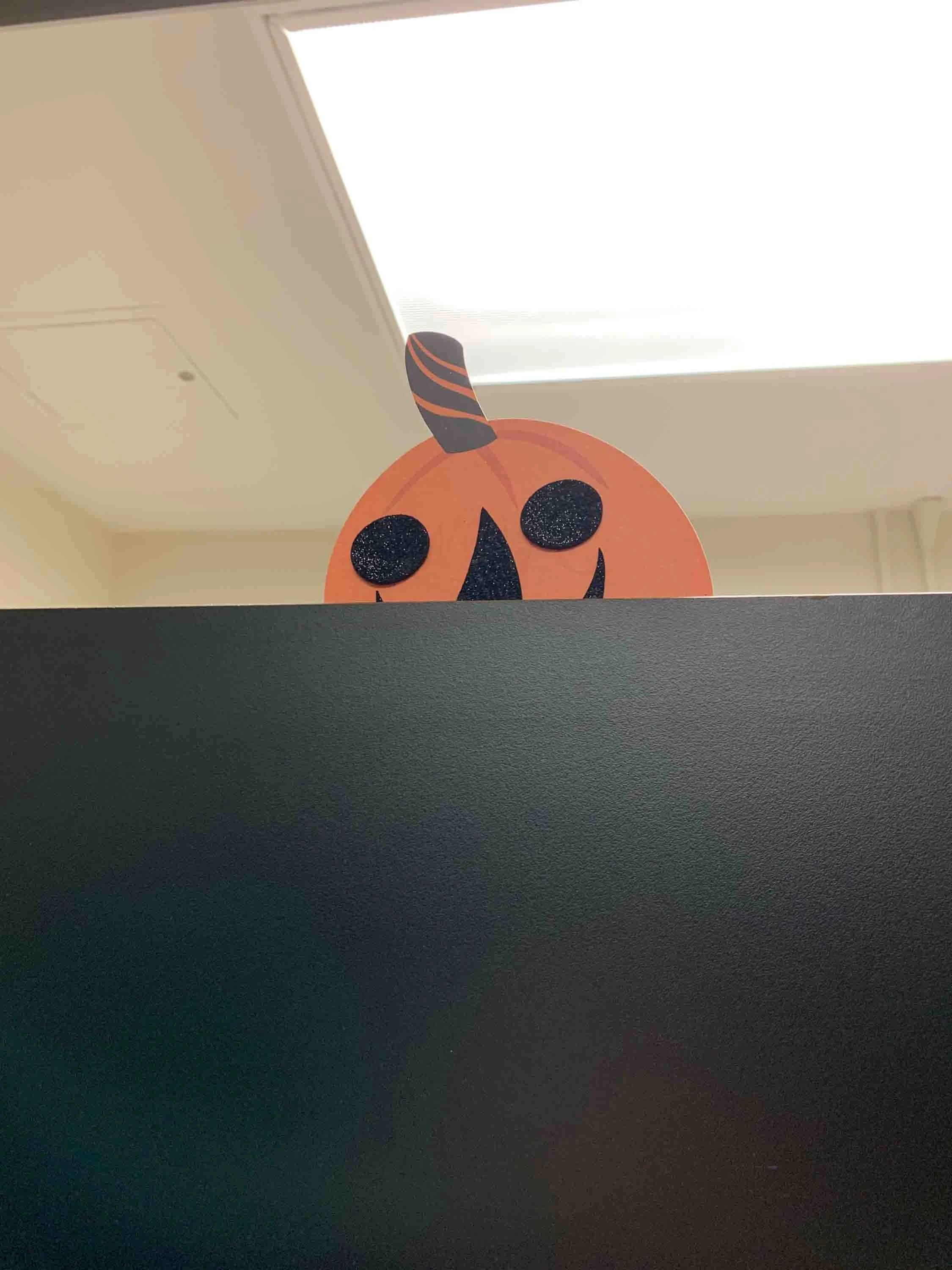 Pumpkin peaking into bathroom stall