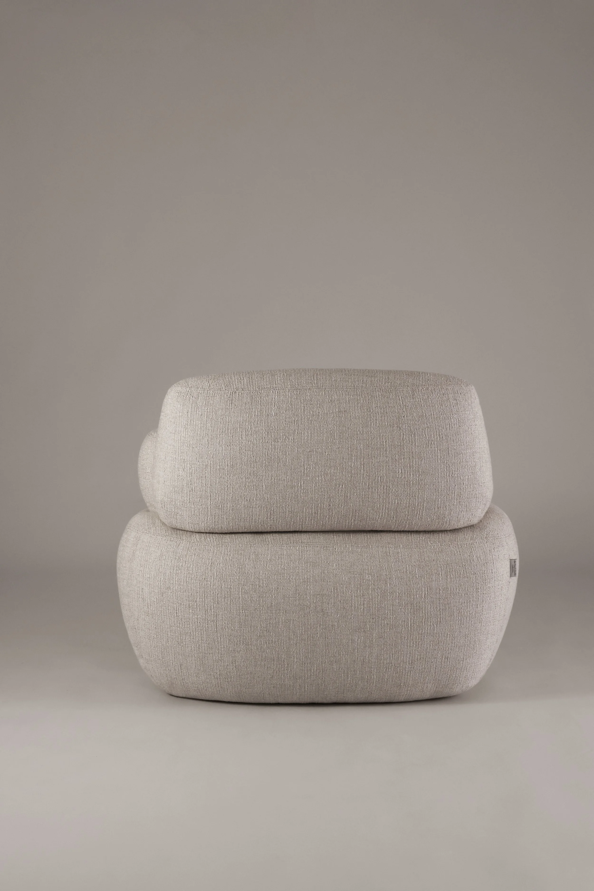 Rear view profile of the Sekitei armchair from The Touch Studio Collection, emphasizing its monolithic yet soft architectural presence.