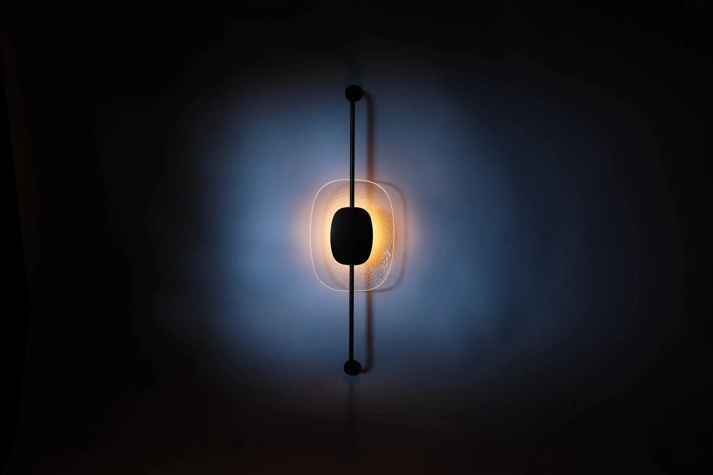 Warm amber illumination of the Drop Light II. The 2700K integrated LED highlights the hand-brushed metallic core and the organic texture of the glass.