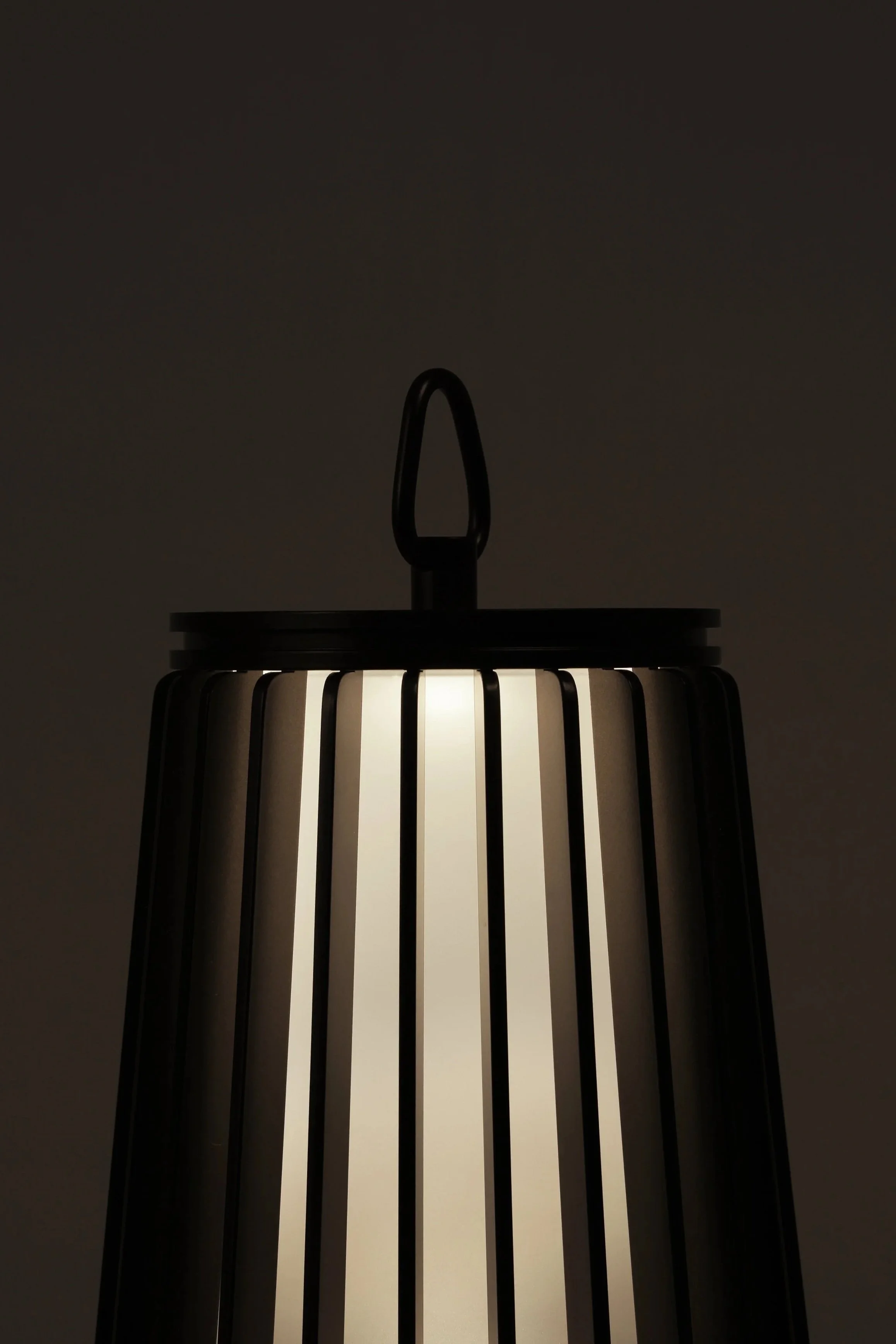 Dune Lantern carried by its leather handle, portable design