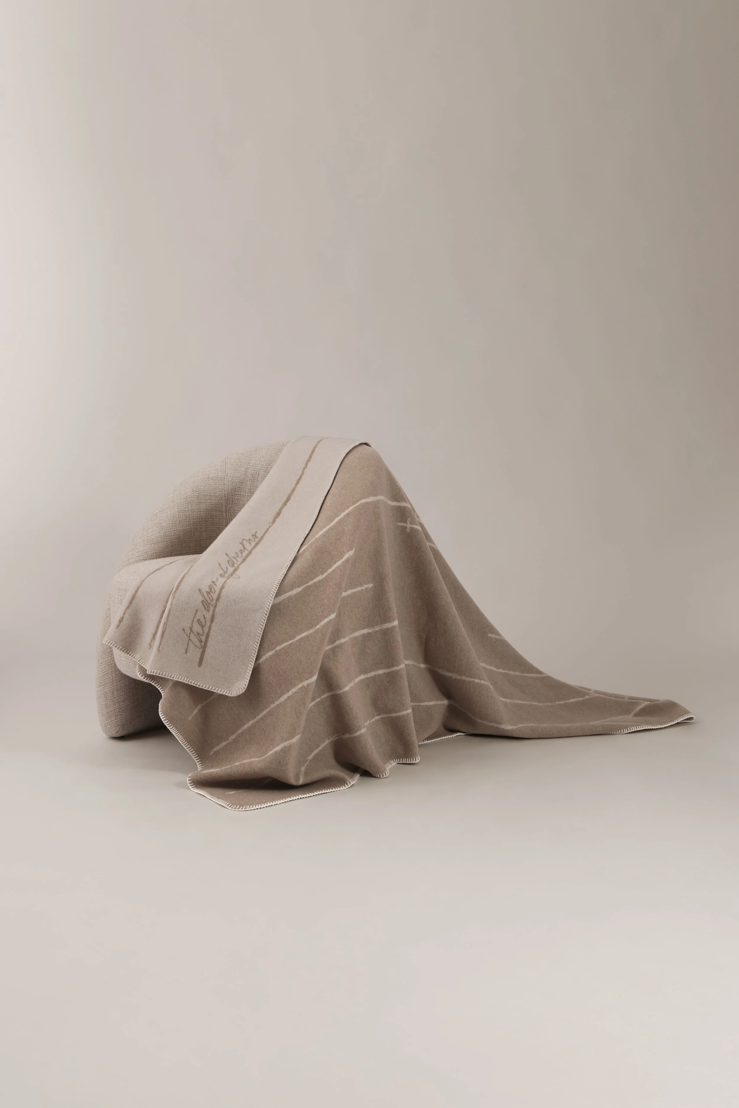 Minimalist home decor styling with a merino cashmere throw draped over a modern designer chair.