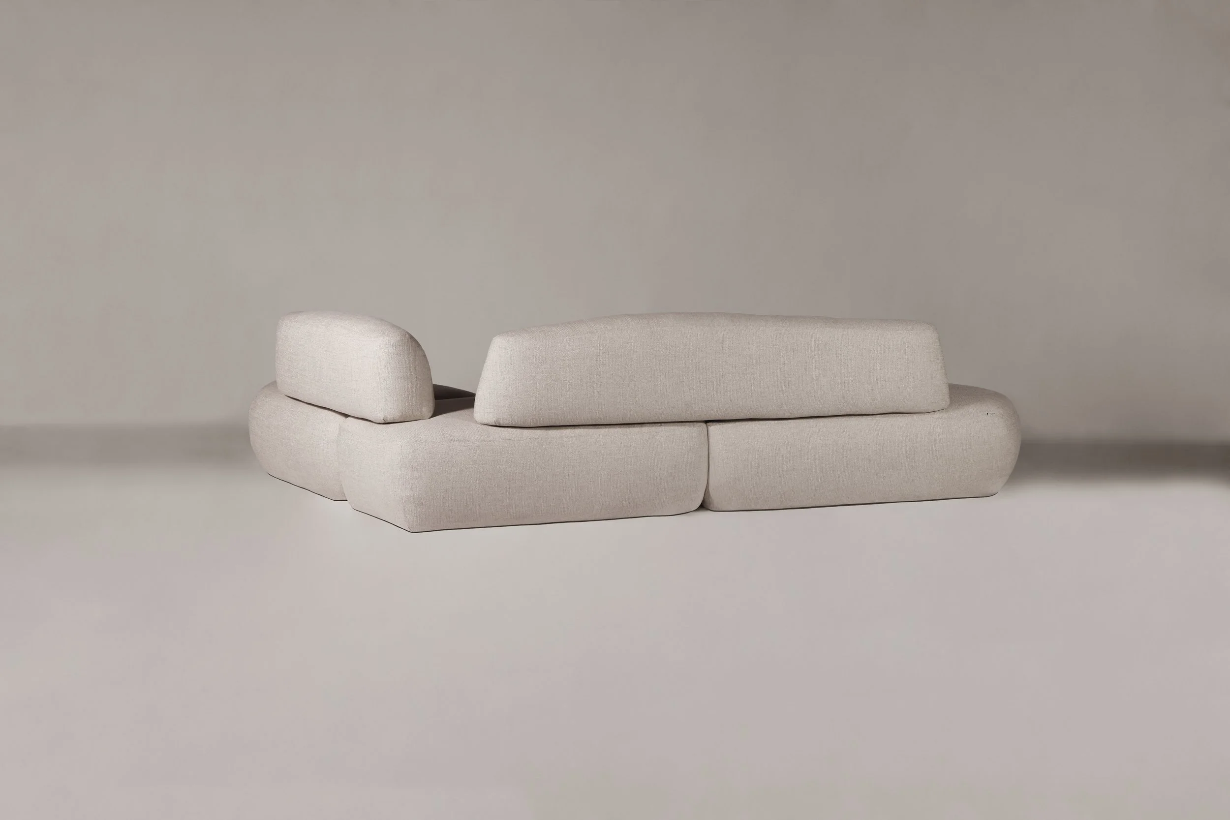 Rear view of the Sekitei Sofa, highlighting its continuous organic lines and timeless monolithic shape designed for contemplation.