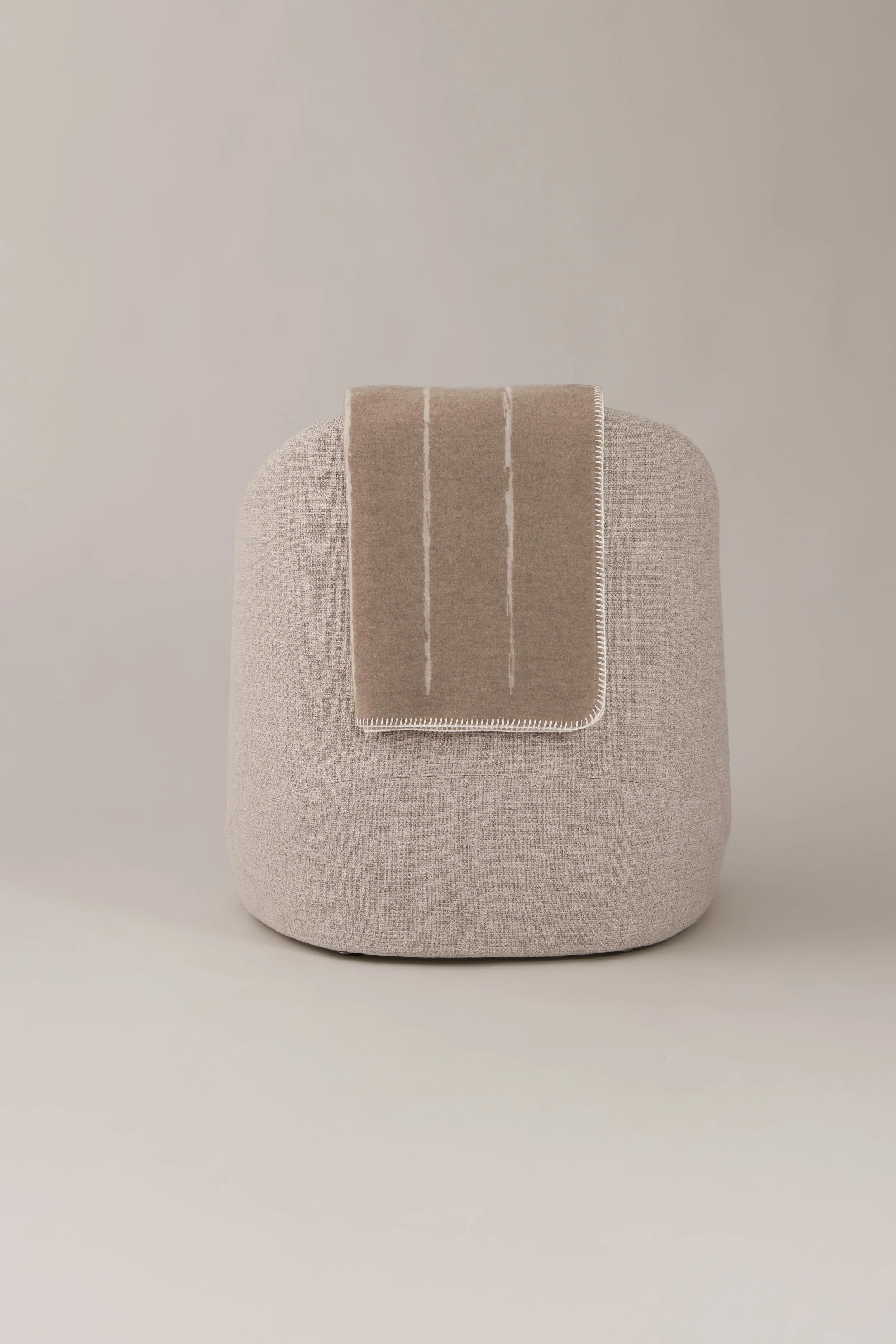 Minimalist home decor styling with a merino cashmere throw draped over a modern designer chair.