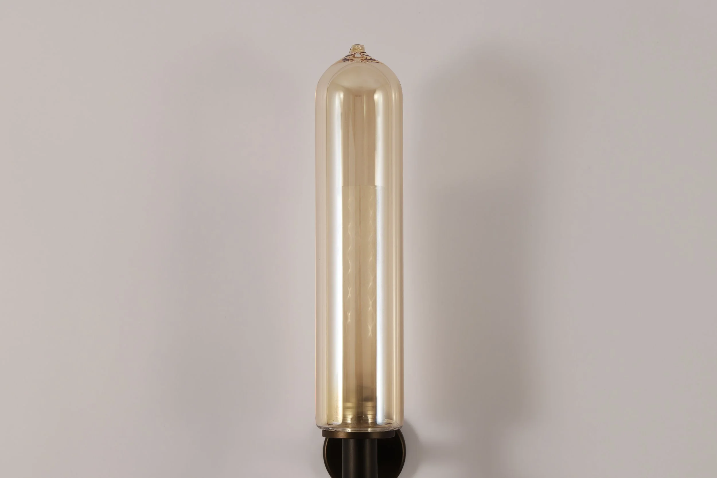 Close-up of the artisanal bronze-tinted hand-blown glass of the BEE Applique, showcasing the unique Venetian glassmaking texture.