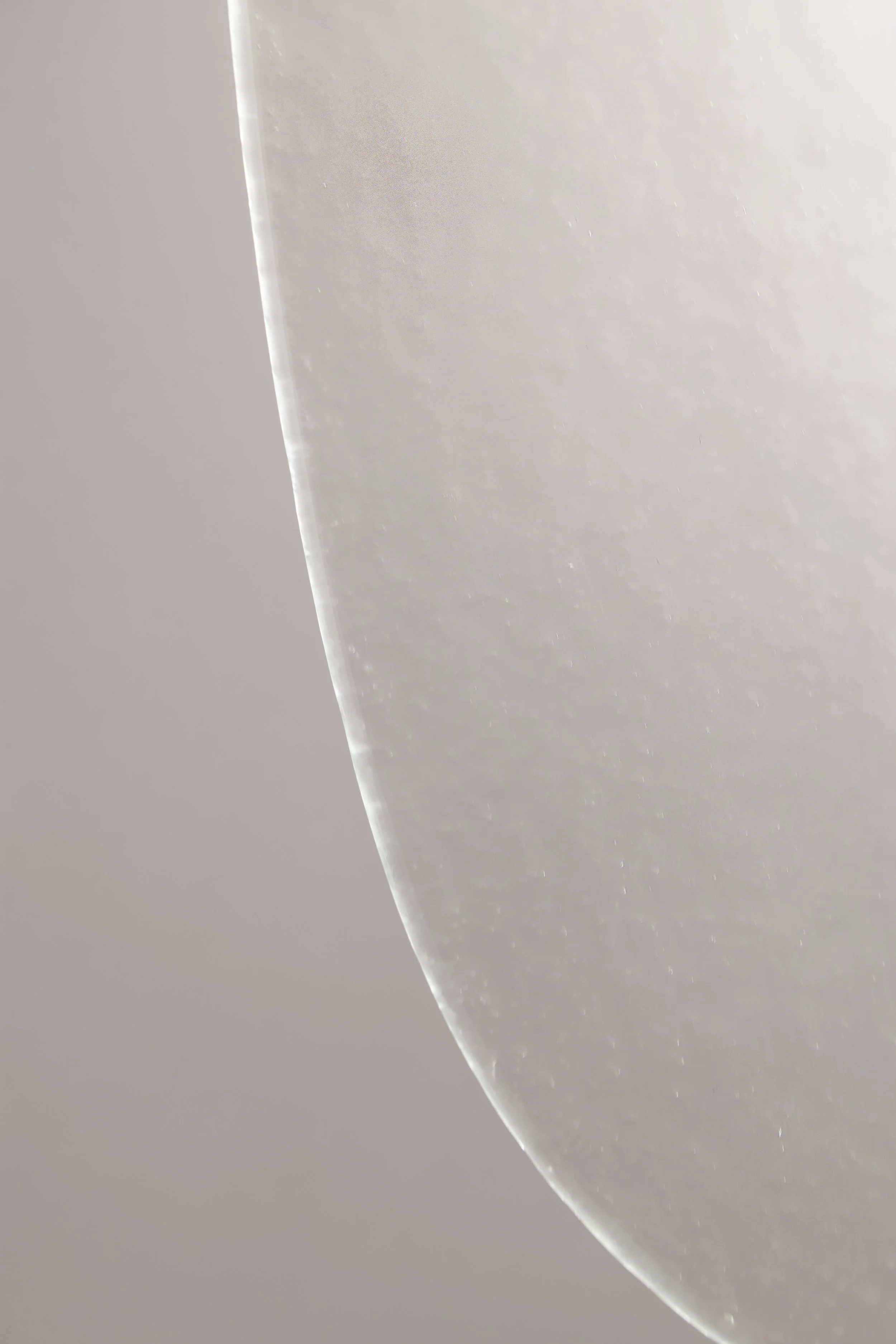 Close-up detail of the artisan glass on the Drop Light II. The aquatic texture creates a rippled water effect when illuminated, showcasing Italian glassmaking craftsmanship.