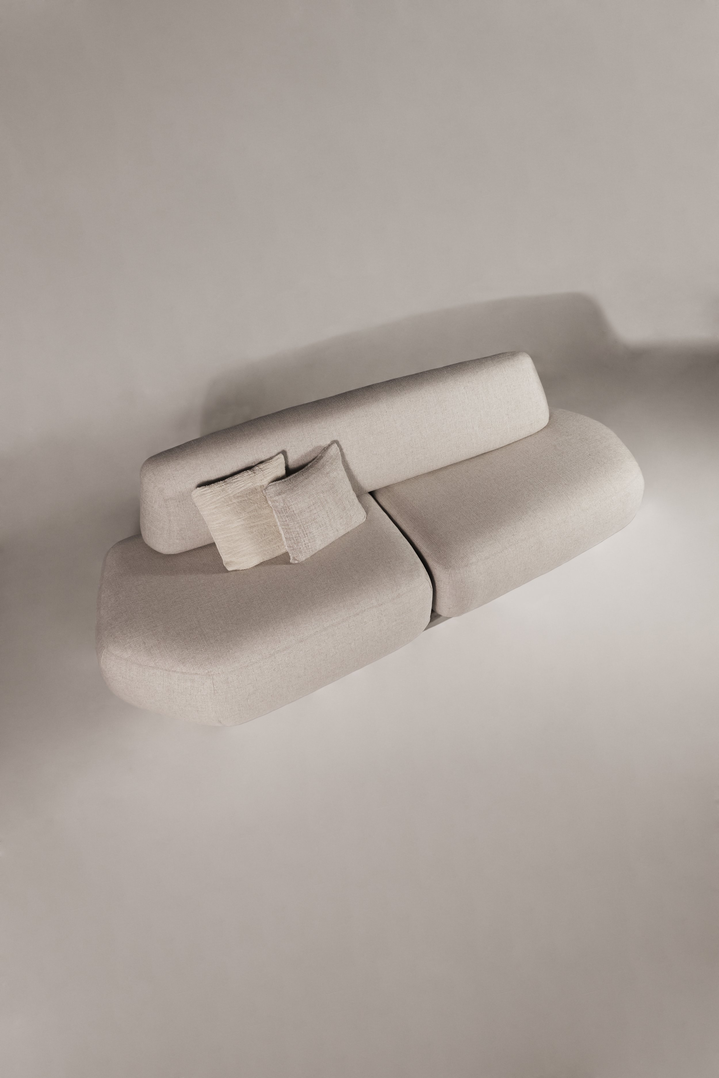High-angle perspective view of the Sekitei linear sofa, showcasing the continuous depth and fluid geometry of the seating.