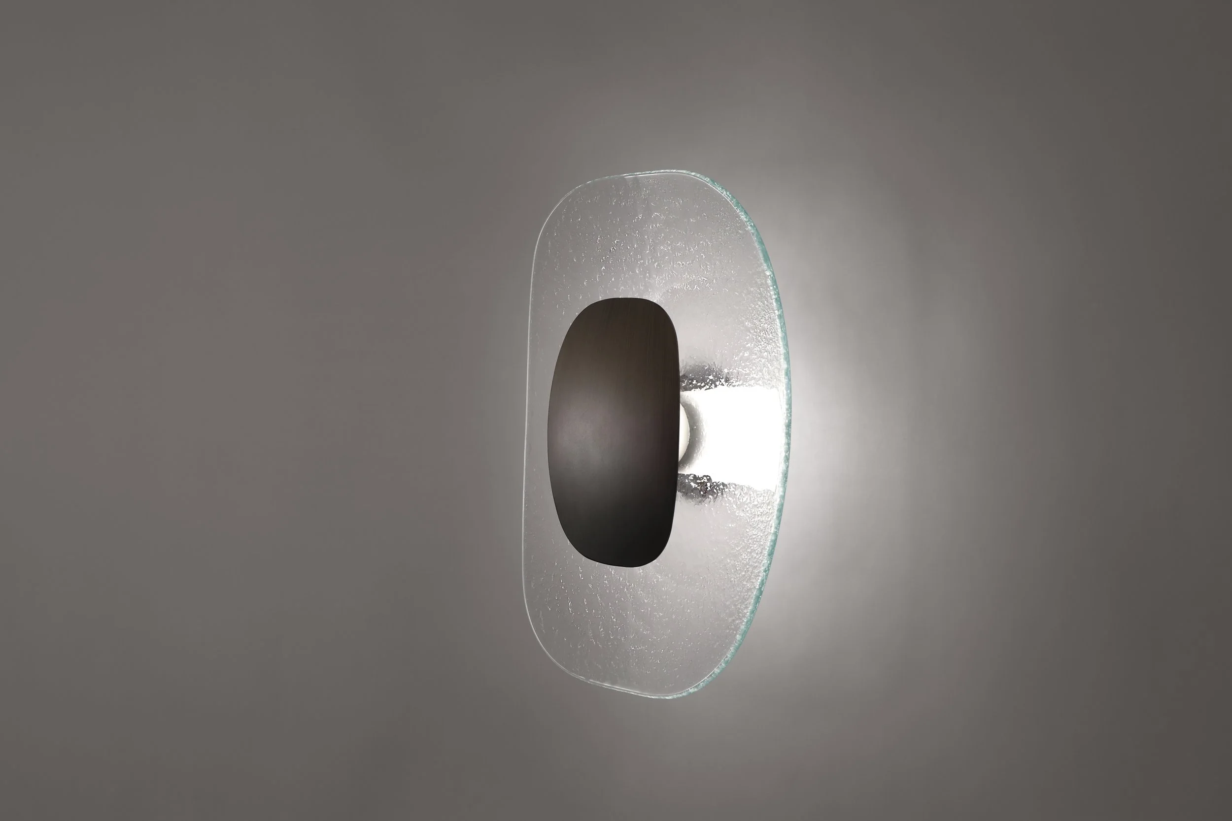 A sculptural silhouette of the Drop Light, showcasing the intersection of hand-brushed metal and artistic cast glass.