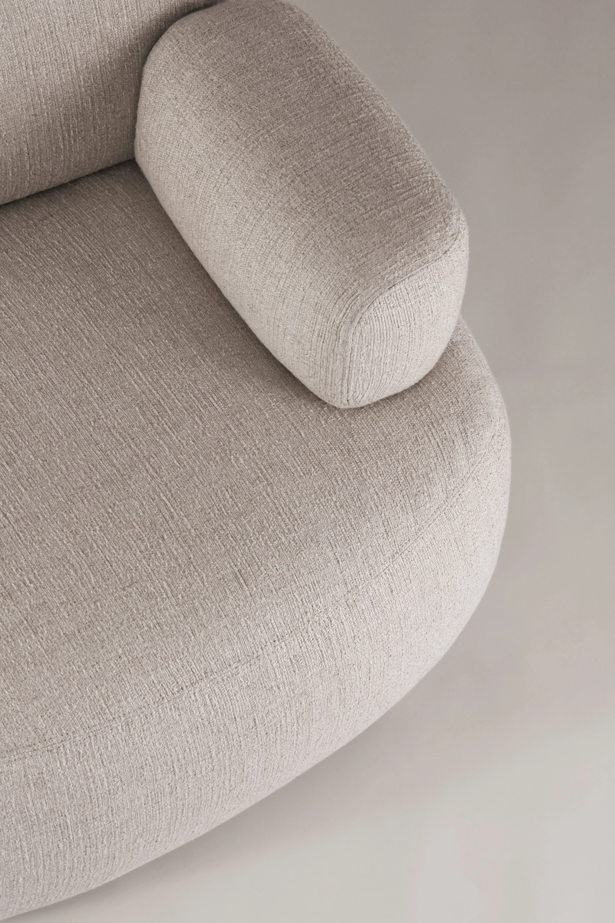 Macro top detail of the Sekitei armchair single armrest, highlighting the soft organic tailoring and bespoke interior flexibility.