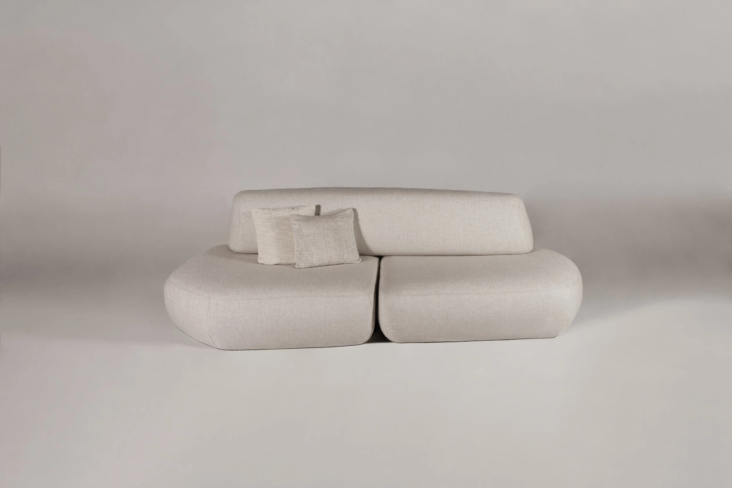Front view of the Sekitei linear straight sofa with accent pillows, highlighting its calm, zen-inspired architectural presence.