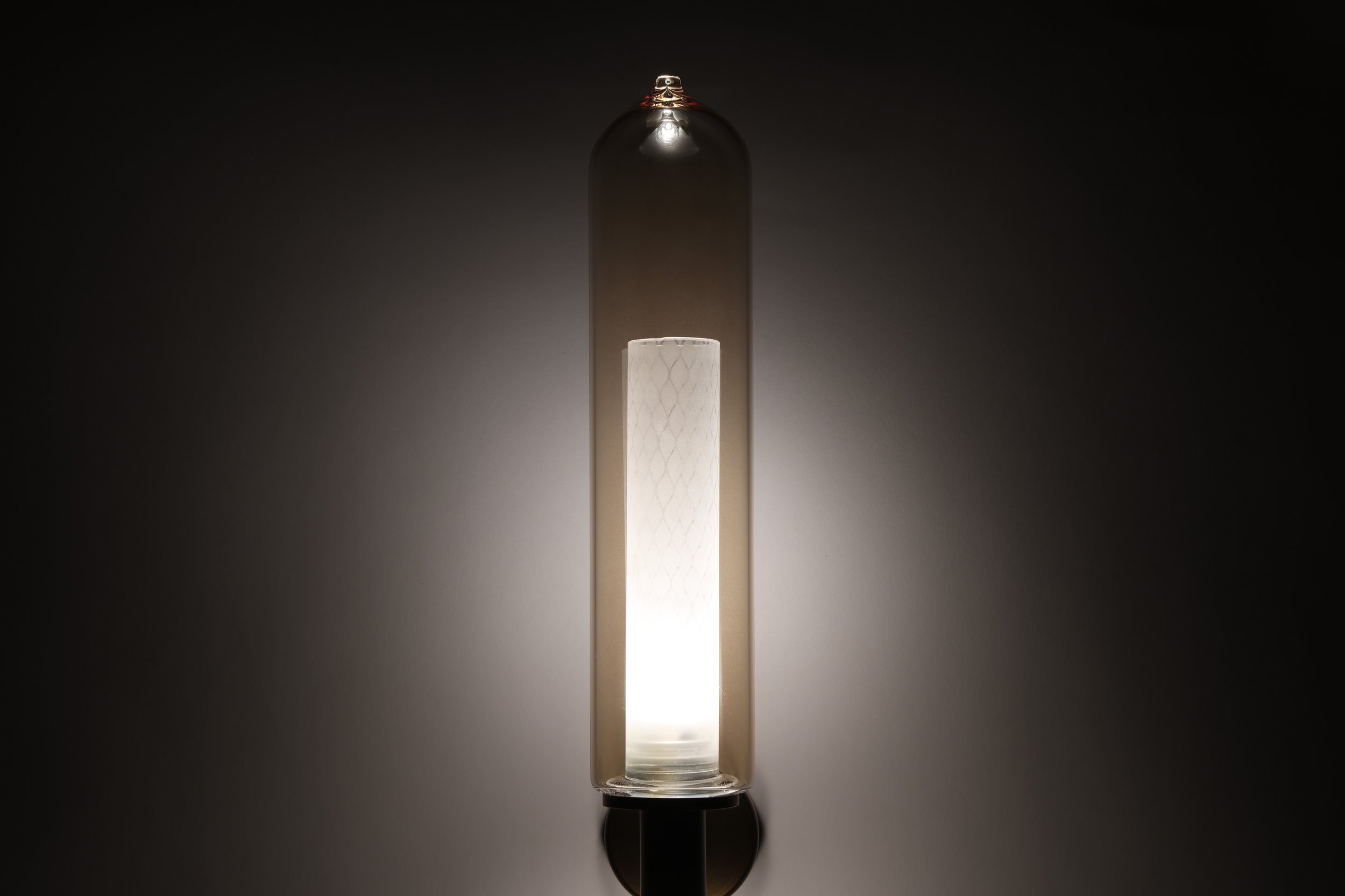 Detailed shot of the Bee Applique illuminated, revealing the internal sandblasted mesh glass technique for soft, warm light diffusion.