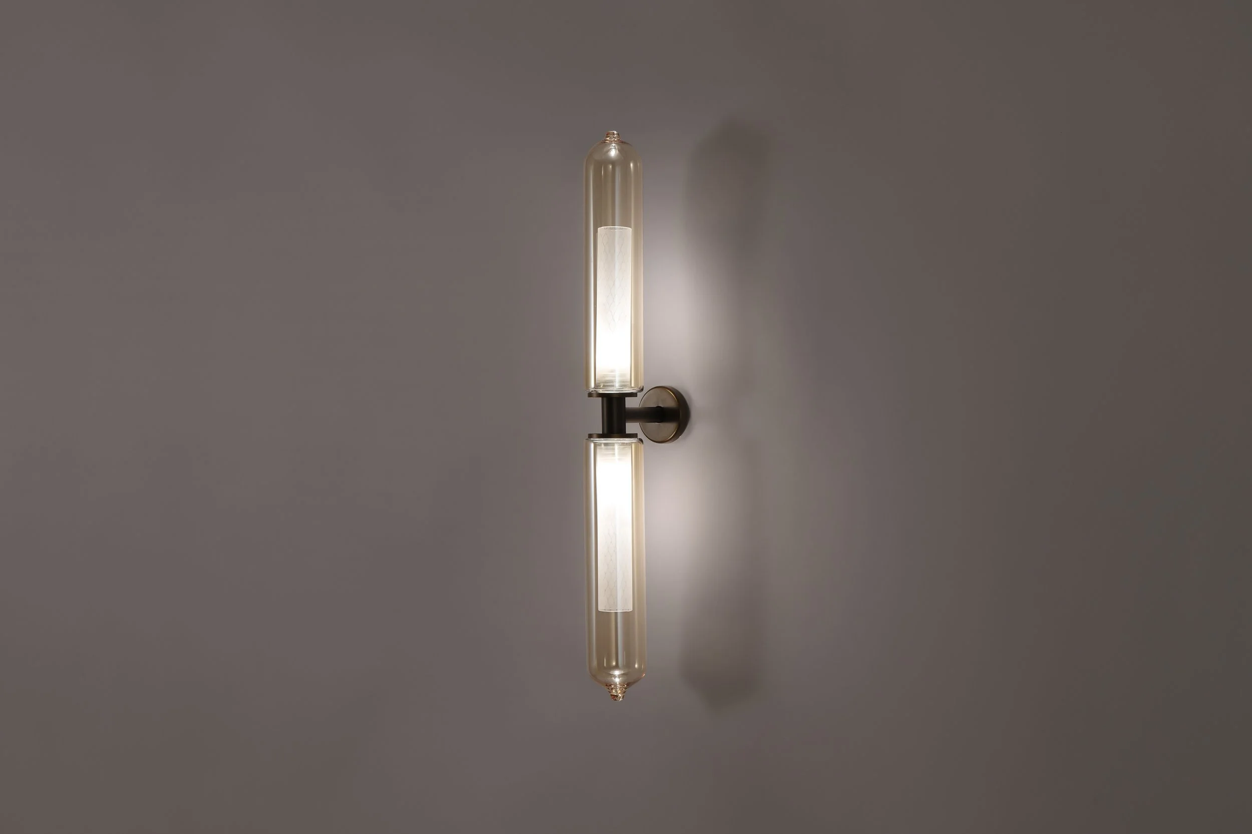 Bee Applique mounted on a clean, minimalist white wall, highlighting its elegant, slender, and sculptural pillar-like silhouette.