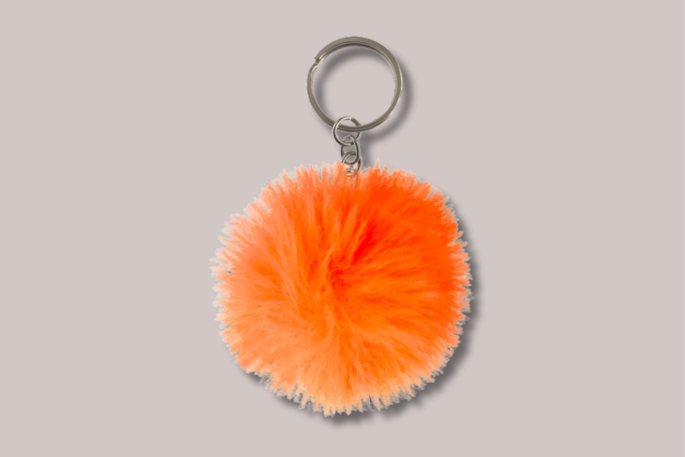 Orange fluffy pom-pom keychain attached to a silver keyring
