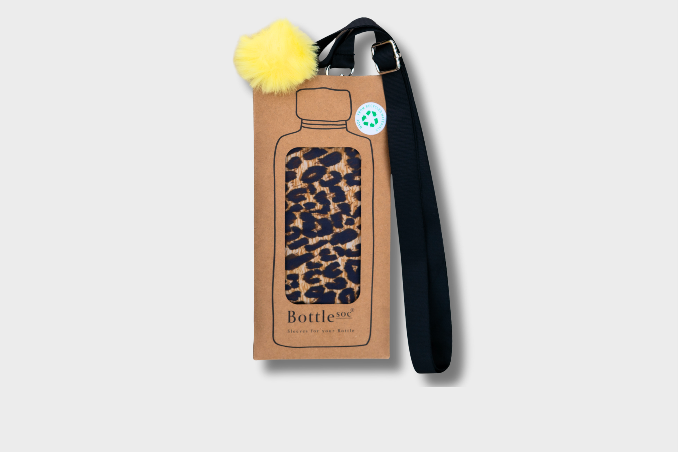 A brown cardboard bottle holder with a clear window showing a leopard print sleeve inside, attached to a black strap, and decorated with a yellow fluffy pom-pom.
