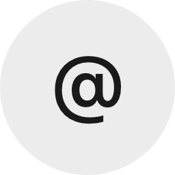 Black at symbol (@) on a gray circular background.