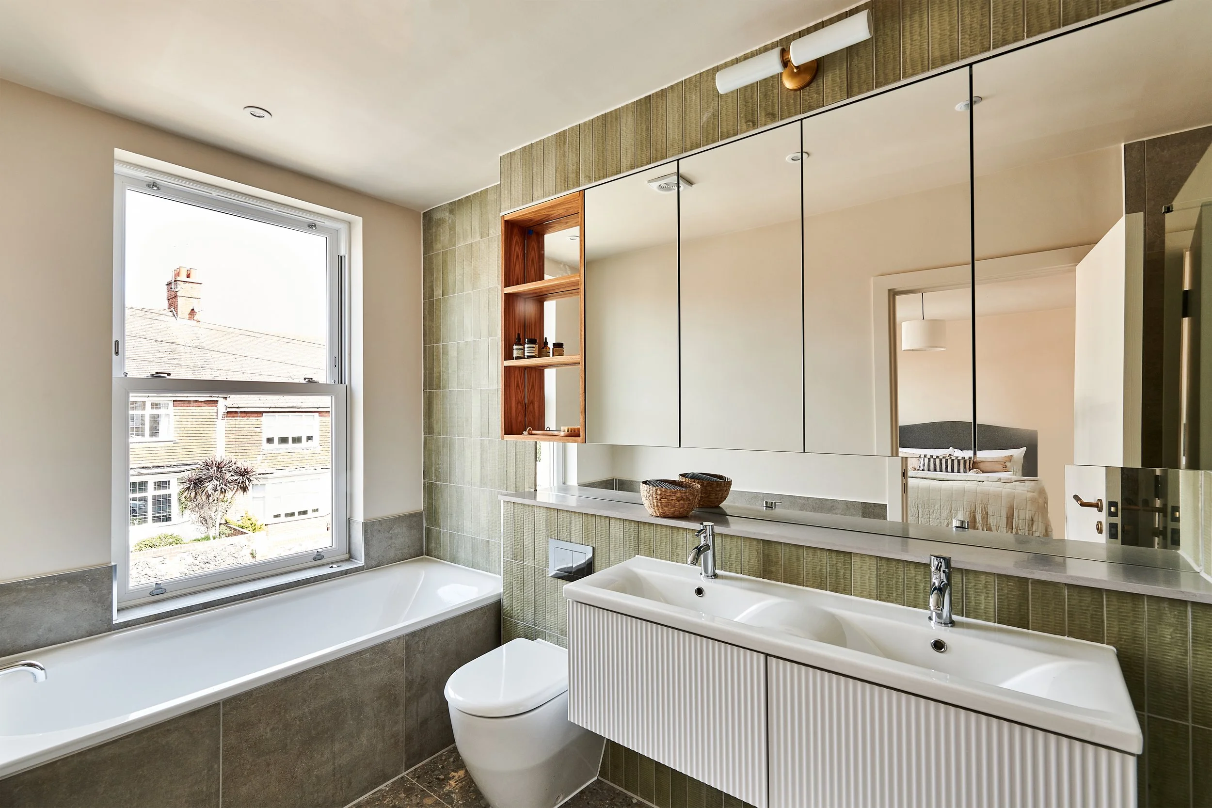 Principle family bathroom with beautifully textured tiling in soft earthy tones. 