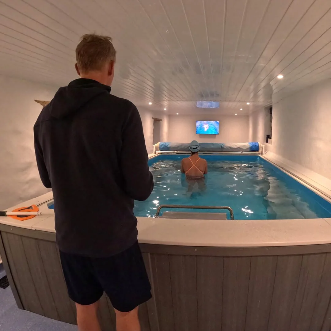 Swim coach at an endless pool with swimmers
