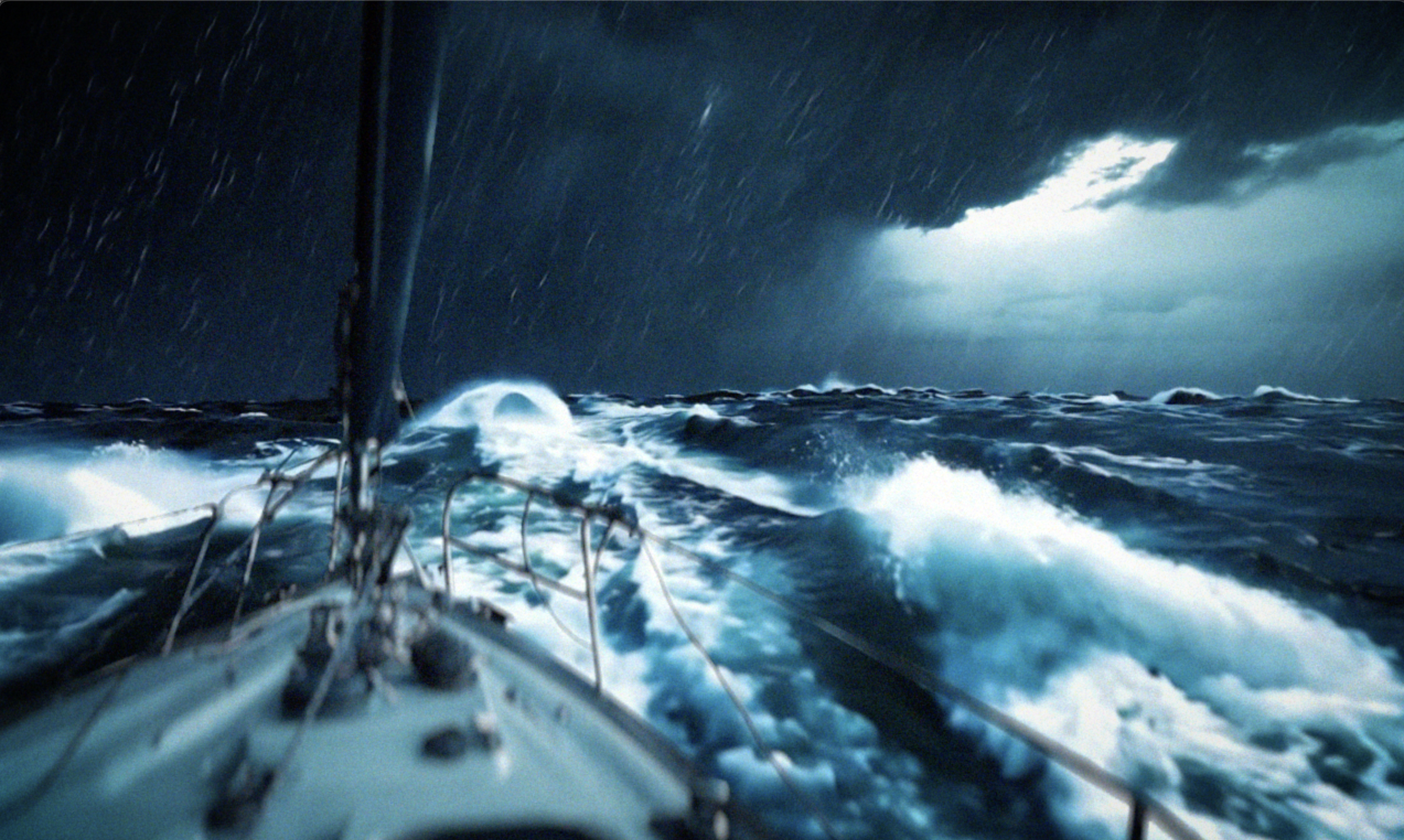 Stormy sea from a boat with dark clouds and lightning in the sky.