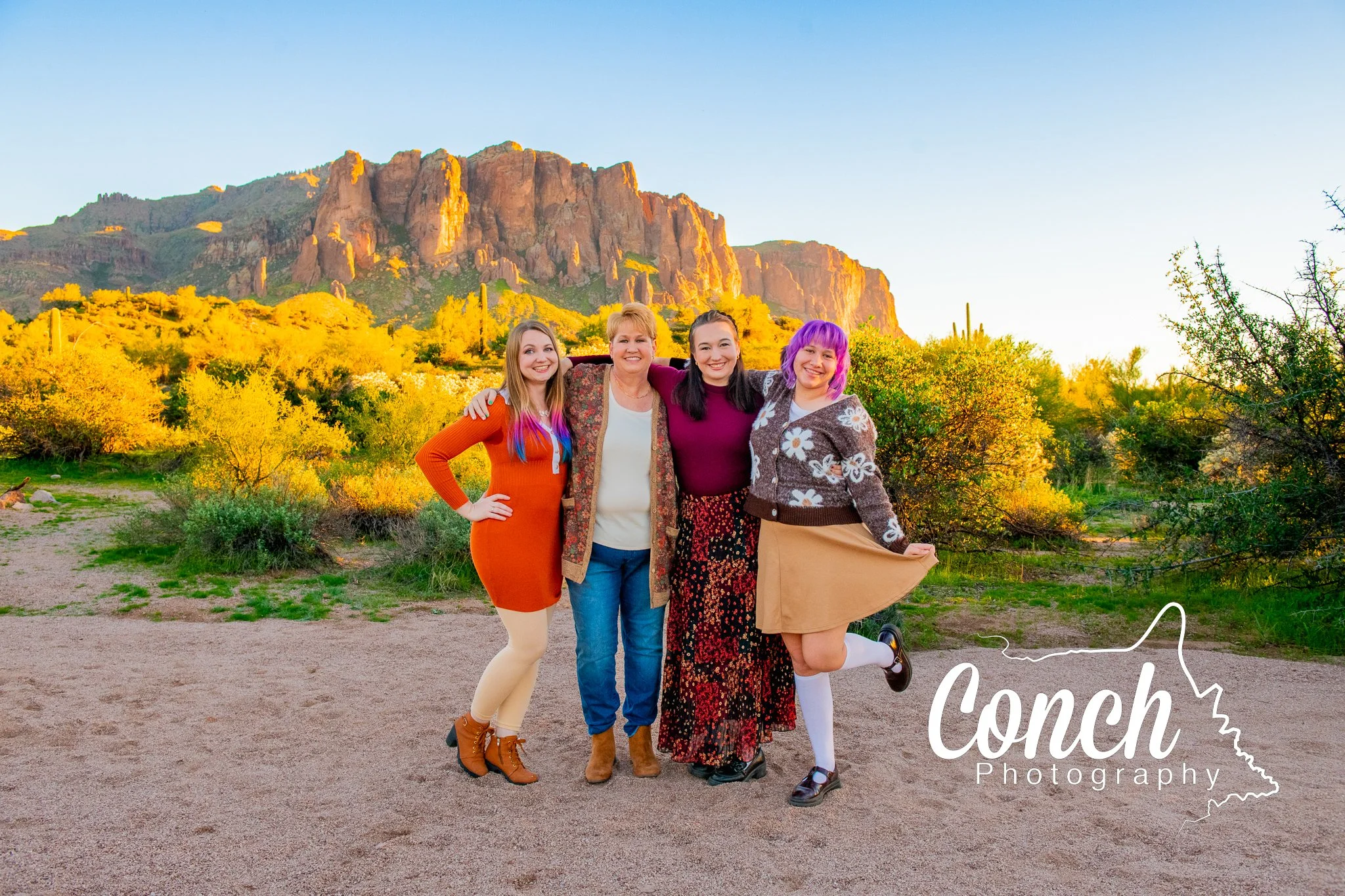 Mother and Daughters pose together in front of the Superstition Mountains at Sunset