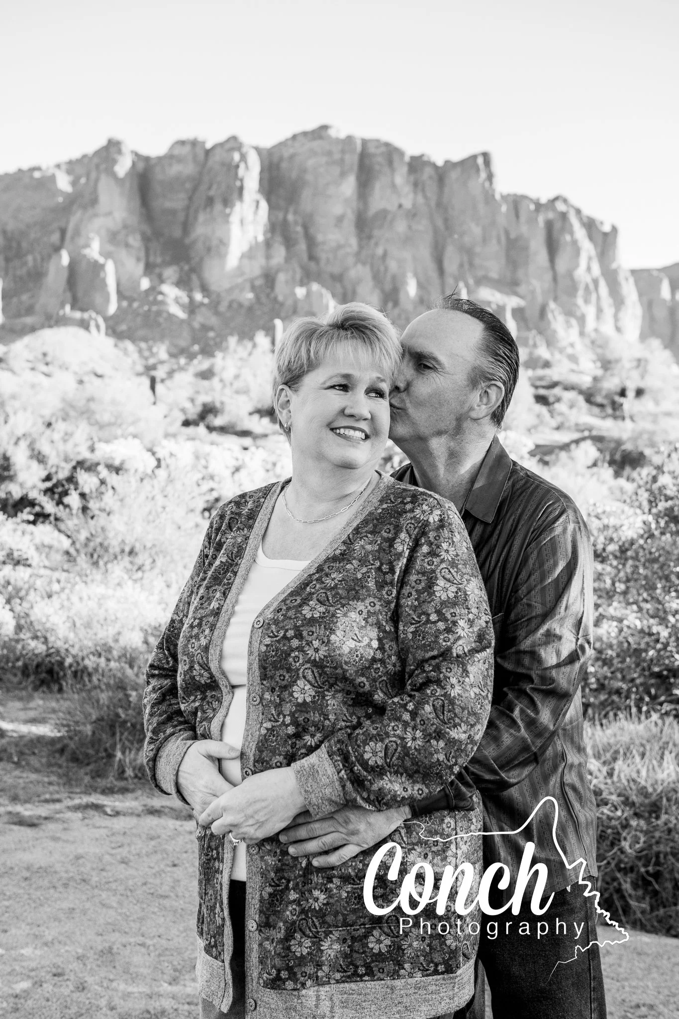 Black and White close up image of a Mother and Father lovingly holding each other at First Water Trailhead
