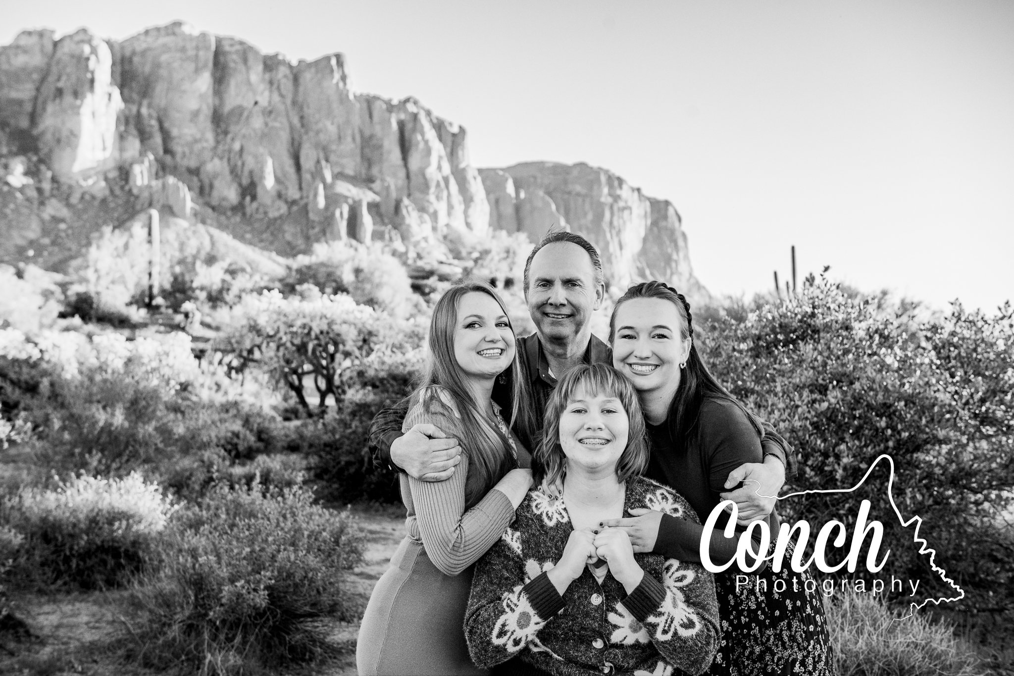 Black and white close up image with a Father and three daughters at First Water Trailhead