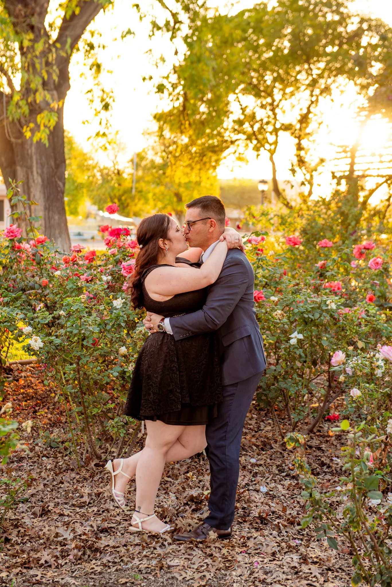 Couple poses amongst the rose bushes at the MCC Rose Garden at sunset