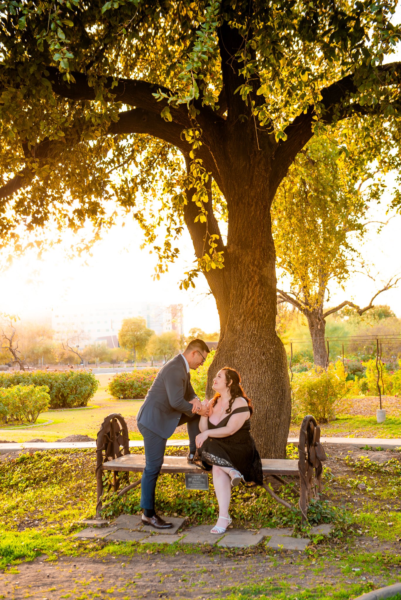 Couple pose on a bench in the MCC Rose Garden at Sunset