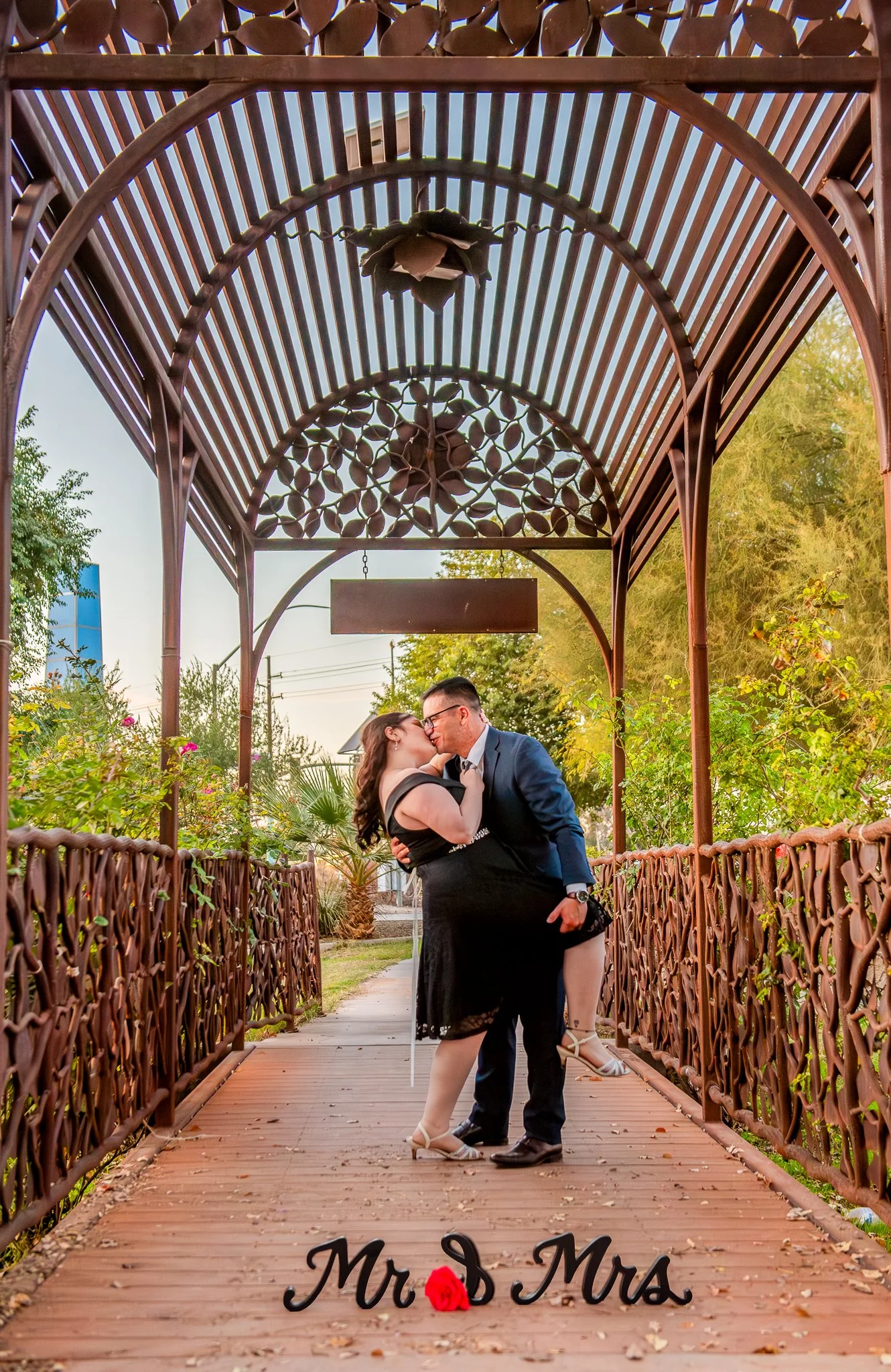Couple kiss on a bridge at the MCC Rose Garden at Sunset