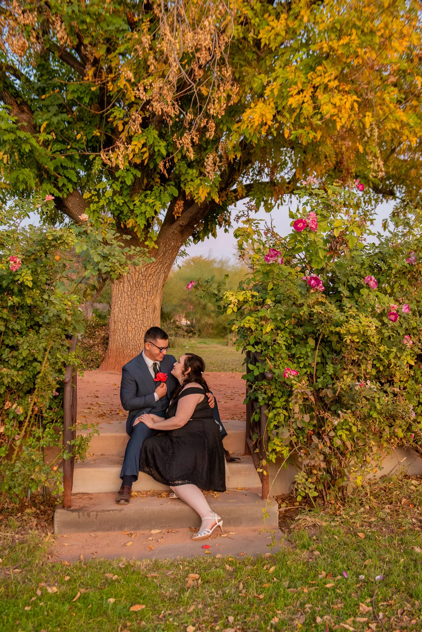 Couple pose on the stairs at Sunset at the MCC Rose Garden