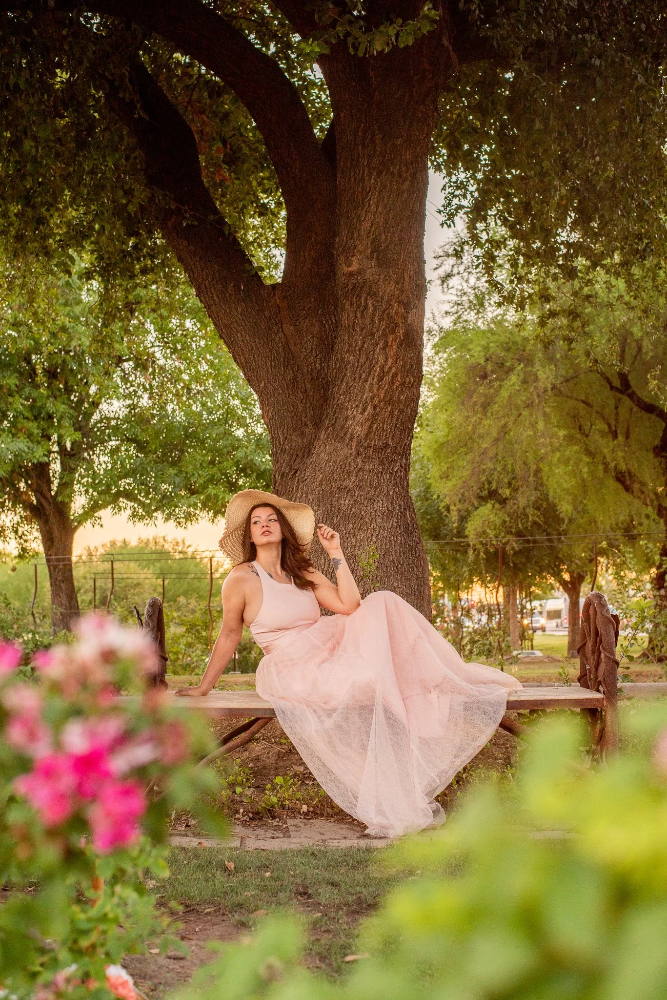 Model sitting with sunhat in the MCC Rose Garden at sunset