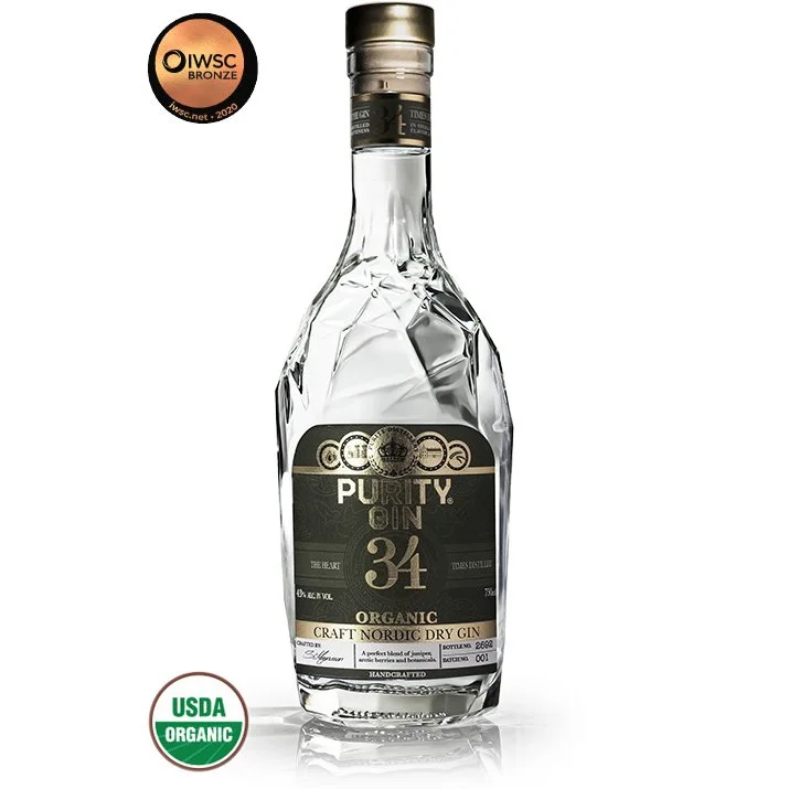 A clear bottle of COCII Purity Gin with black and gold label, organic and handcrafted, 34% alcohol, USDA Organic certified, and IWSQ Bronze award sticker.
