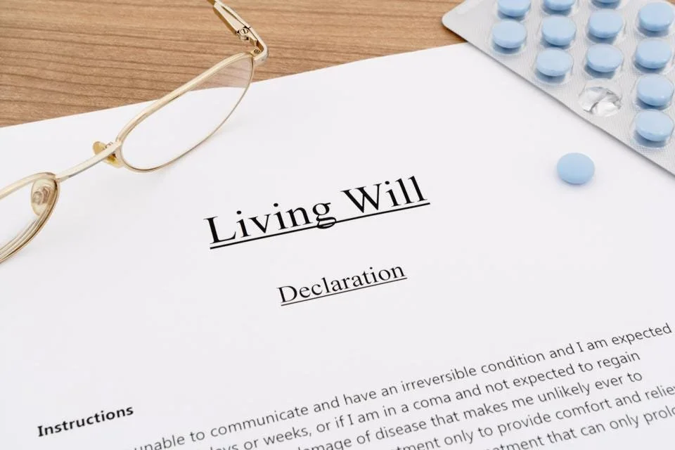 Living will declaration typed on document next to eyeglasses and blue pills