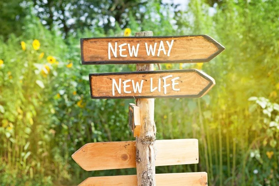 A wooden sign in a grassy area New Way New Life referring to changes that may impact your estate planning