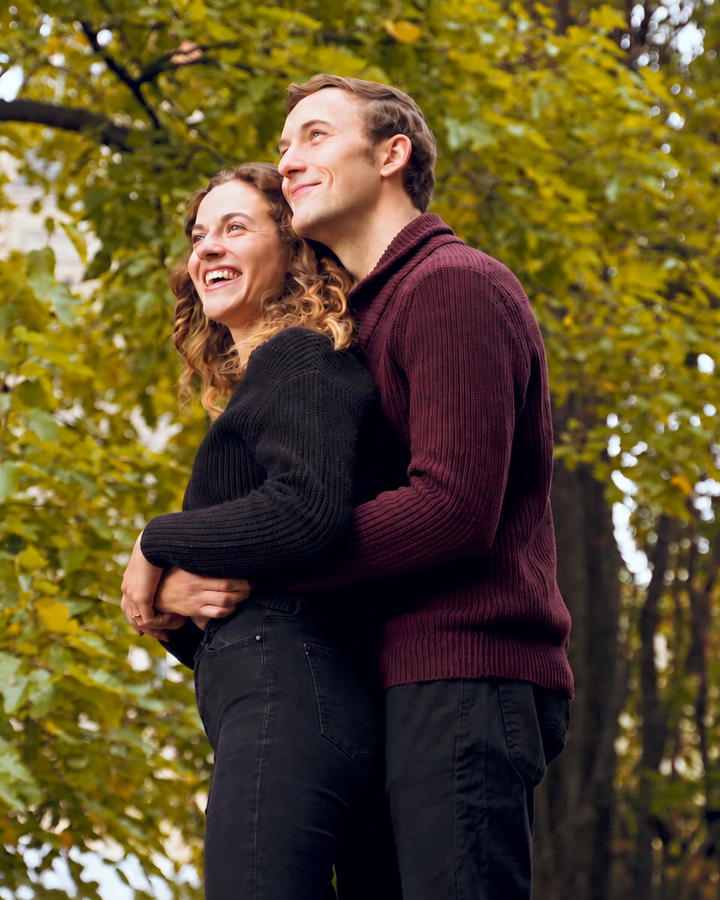 Couple laughing and embracing beneath autumn trees during a pre-wedding Story Session in Toronto.