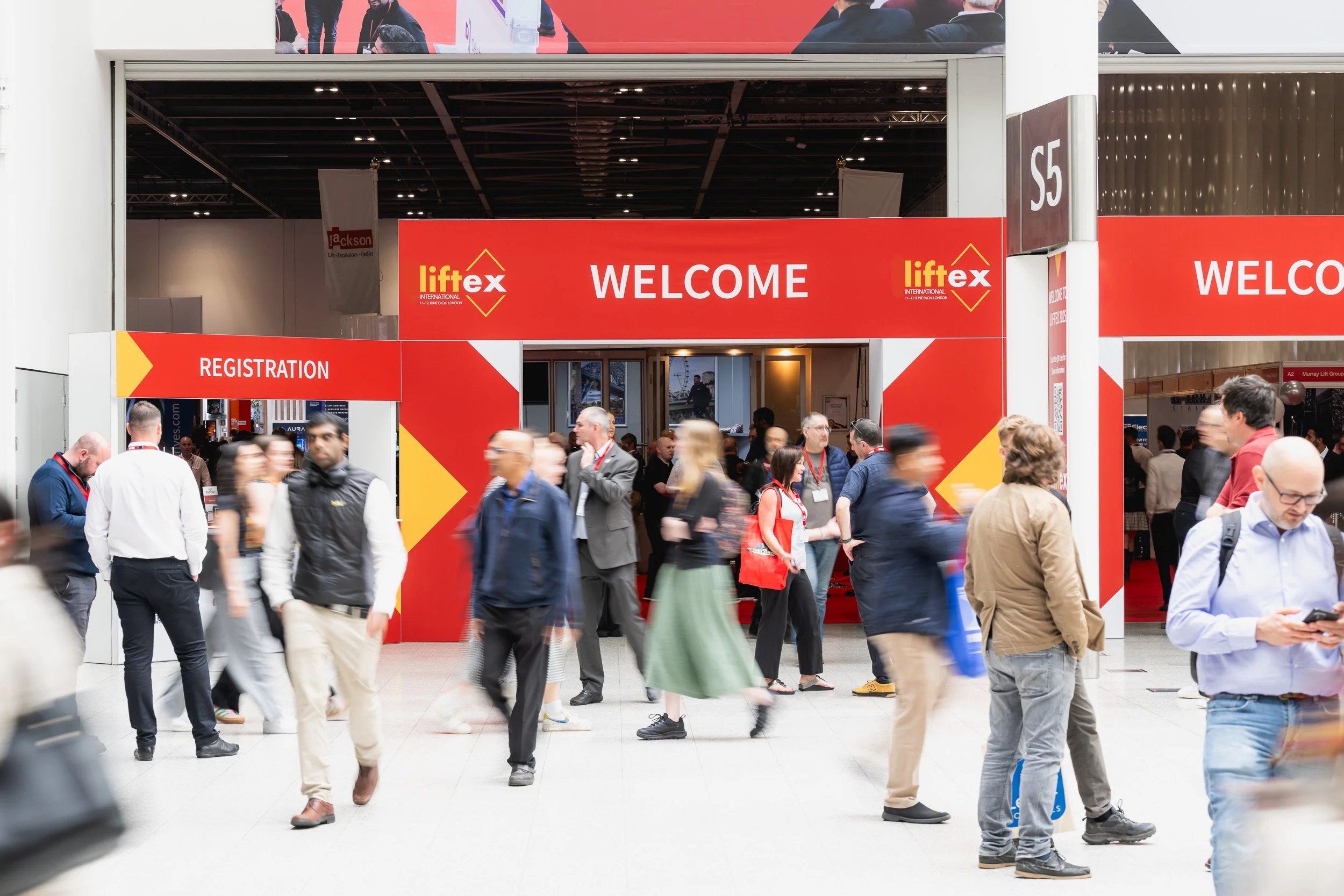 Visitors arriving at the red LiftEx exhibition entrance at ExCeL London.