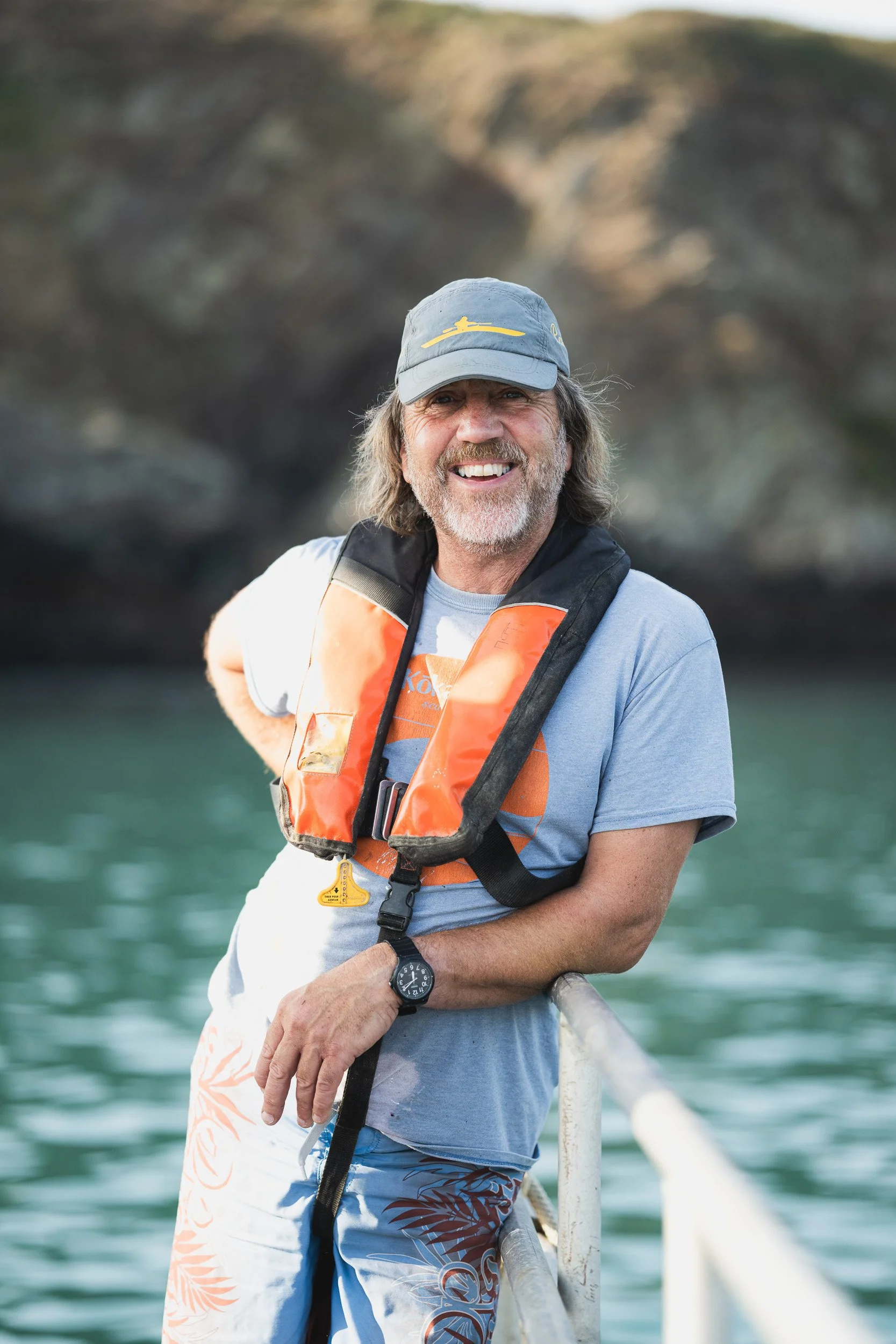 Man wearing a lifejacket aboard a boat during a seaweed farm visit.
