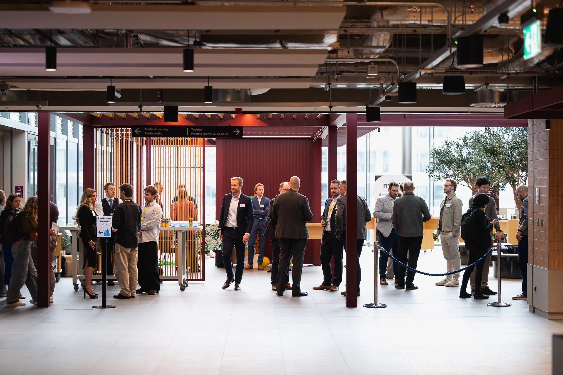 Groups of delegates standing and talking in an open exhibition and networking area.