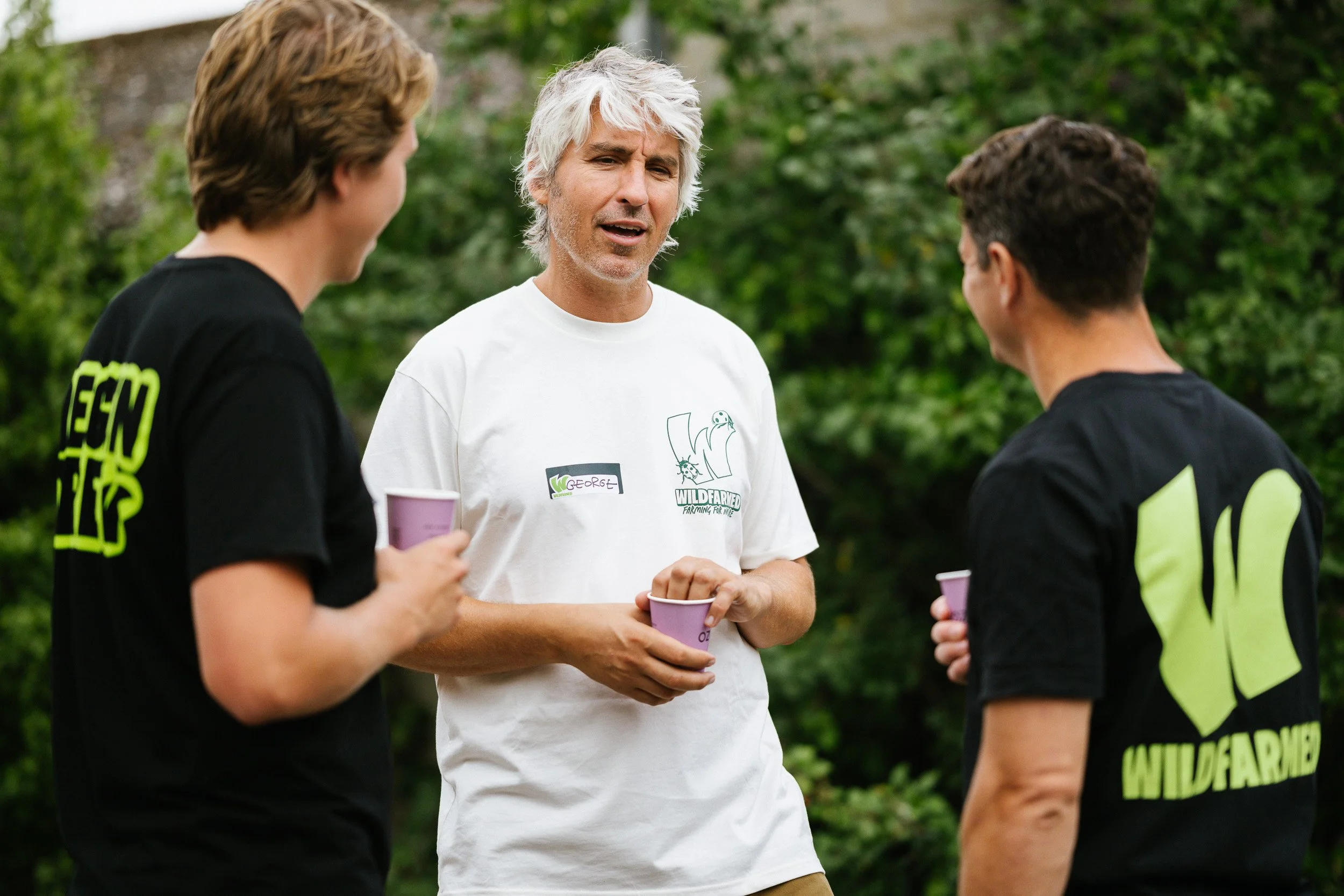 Three people talking during a visit to Wildfarmed.